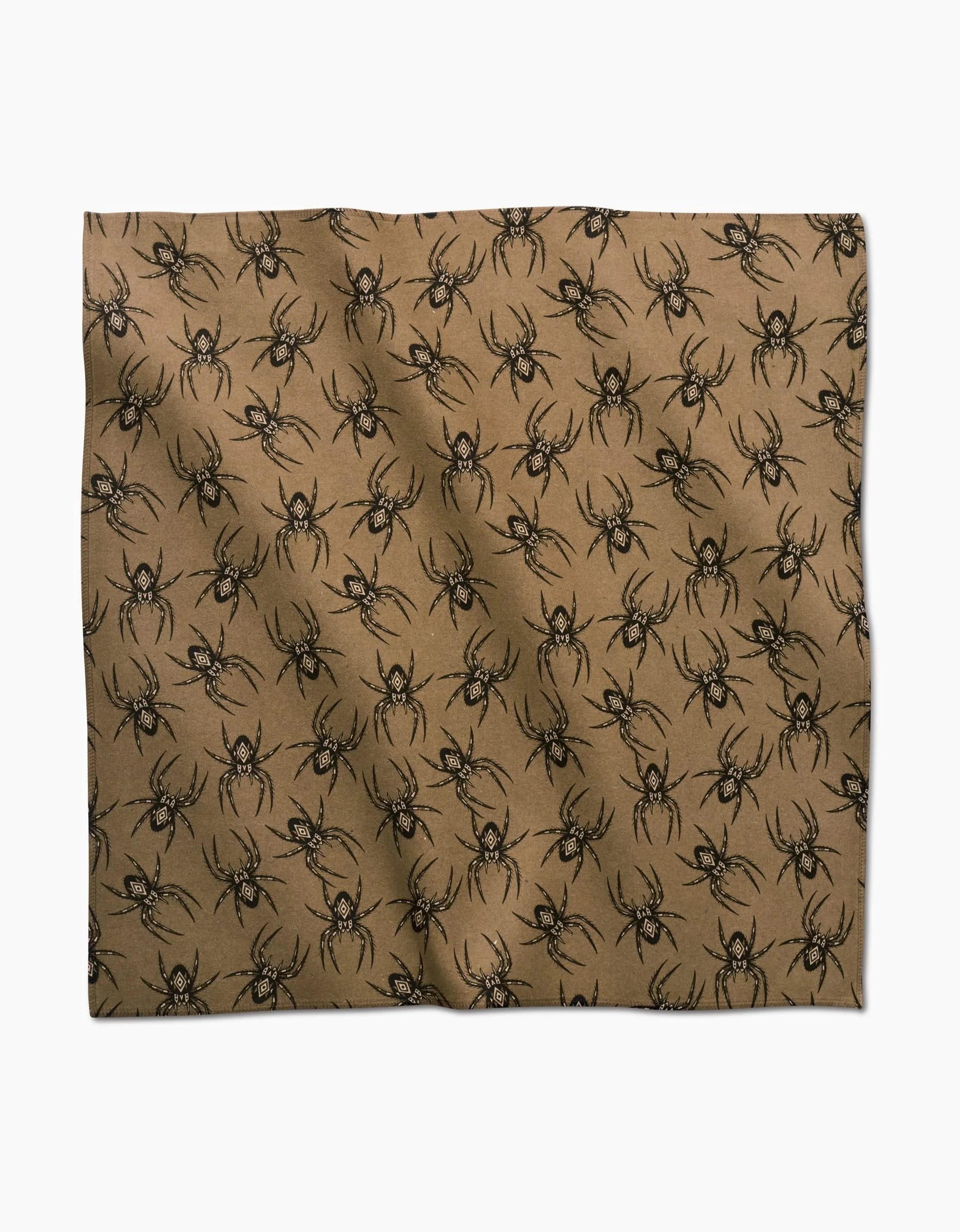 Flash by Cole Strem features tan Geosuede fabric with a repeating pattern of black spiders, slightly wrinkled and displayed on white—ideal for crafting eco-friendly, standout dinner napkins.