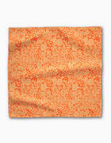 The Florence fabric by Katie OShea features an orange background with a detailed beige floral and leaf pattern, making it ideal for eco-friendly or recycled dinner napkin sets. Its surface is slightly wrinkled and laid flat on white.