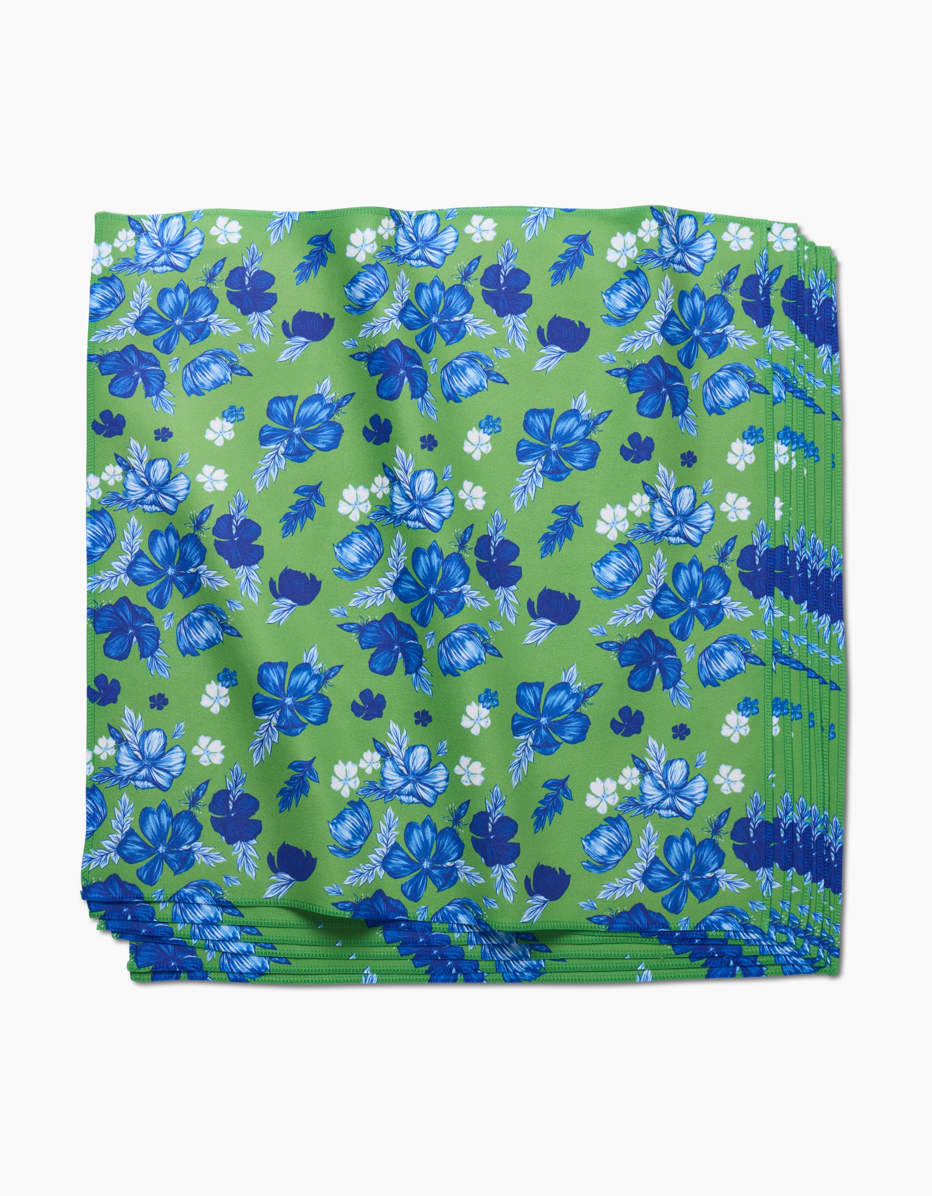 The Flower Bomb Dinner Napkin Set by GEOMETRY features folded green Geosuede fabric with a blue and white floral pattern, crafted from recycled materials for an eco-friendly and stylish table setting.