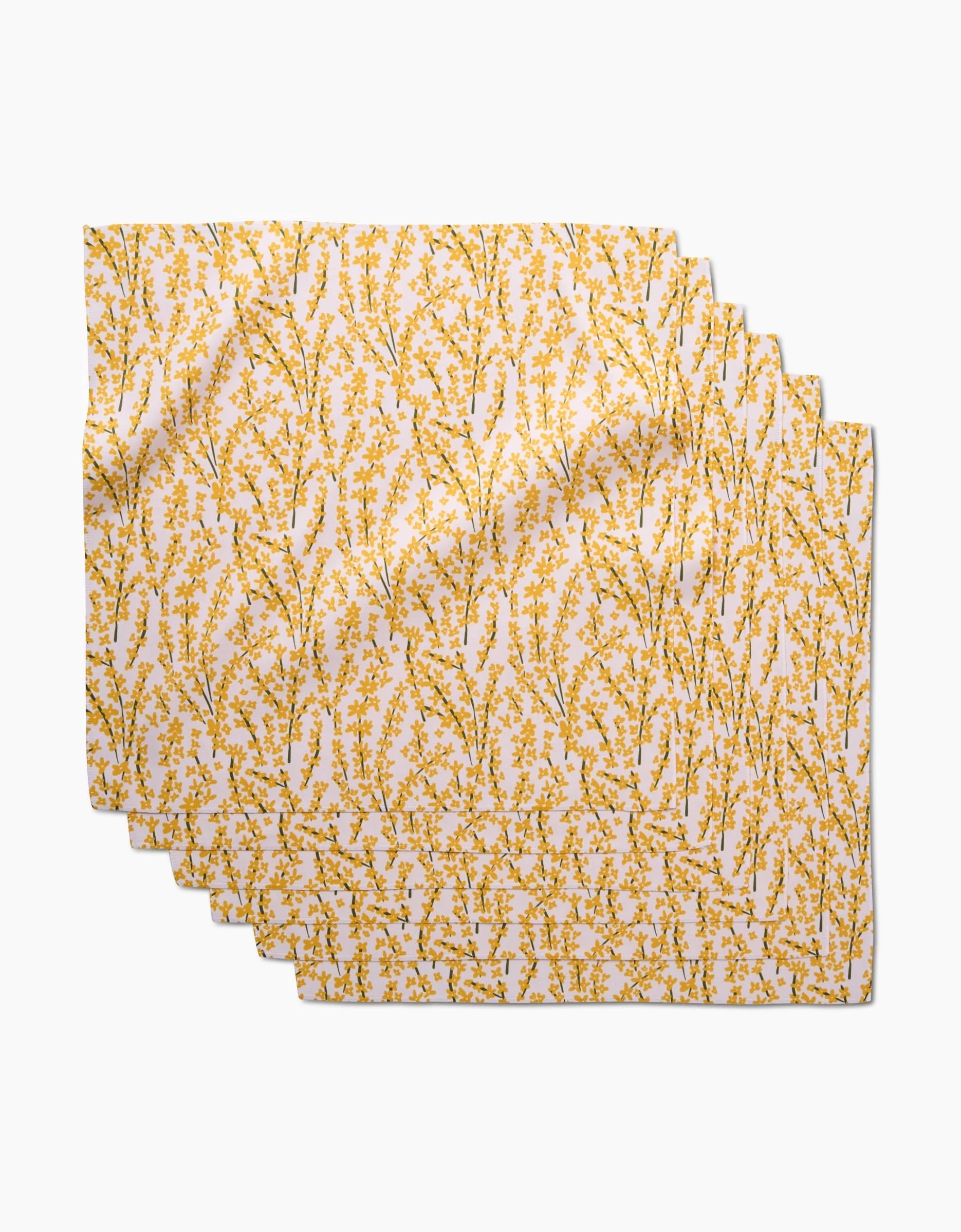 Four Forsythia Floral placemats by Kayla Ann are stacked, each crafted from soft Geosuede fabric with a white background and a yellow floral branch pattern evenly distributed across the surface.