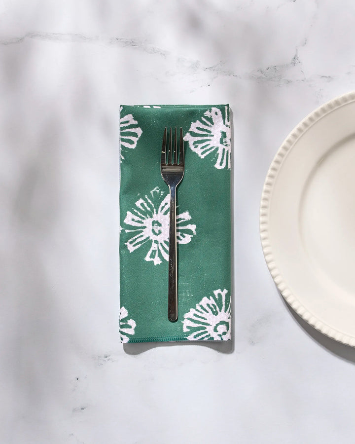 A Geometry Freya washable cloth napkin holds a fork beside a plate.