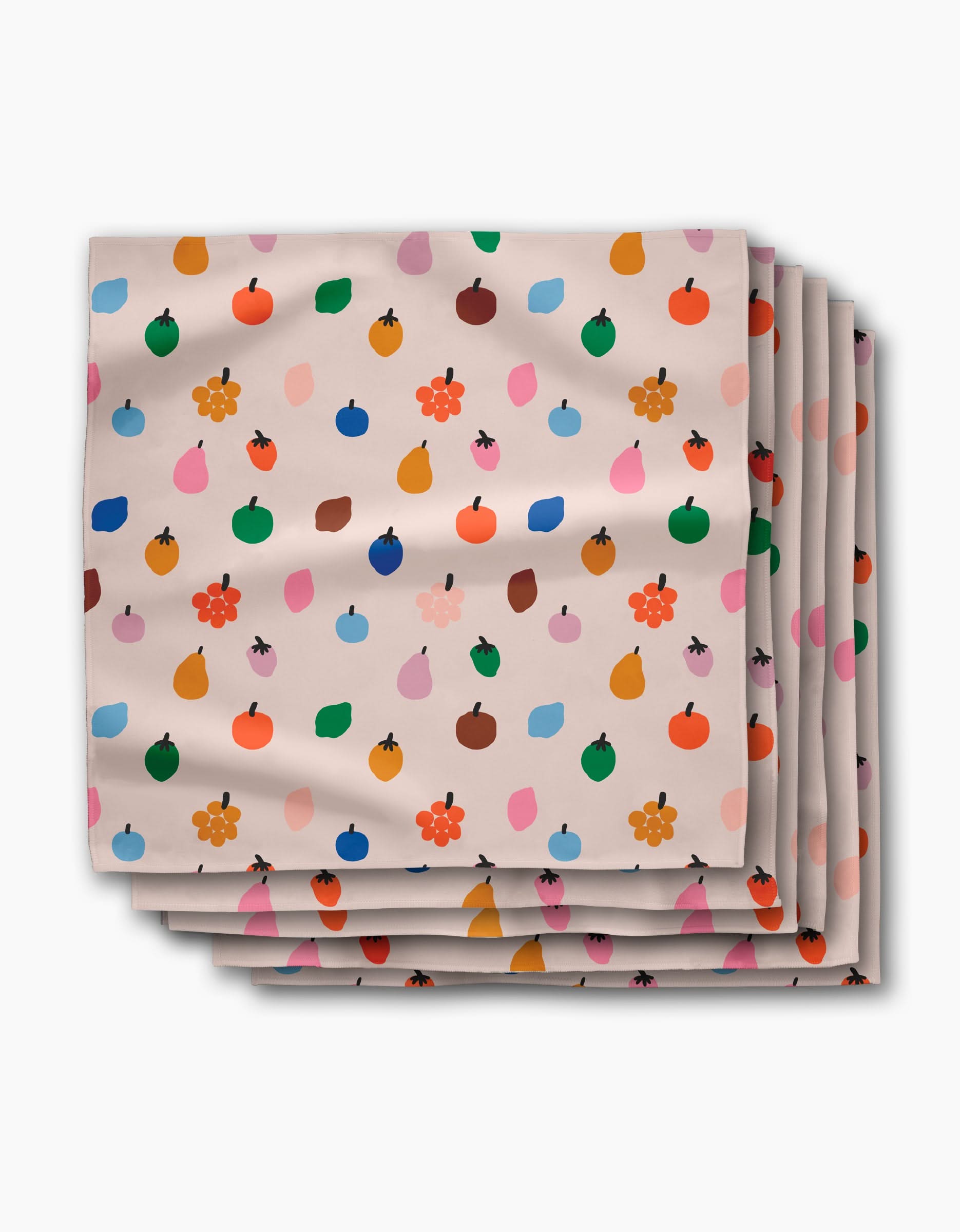 The Jennifer Bouron Fruit Basket Dinner Napkin Set features beige Geosuede™ napkins adorned with vibrant fruit and flower patterns in red, blue, orange, green, and pink.