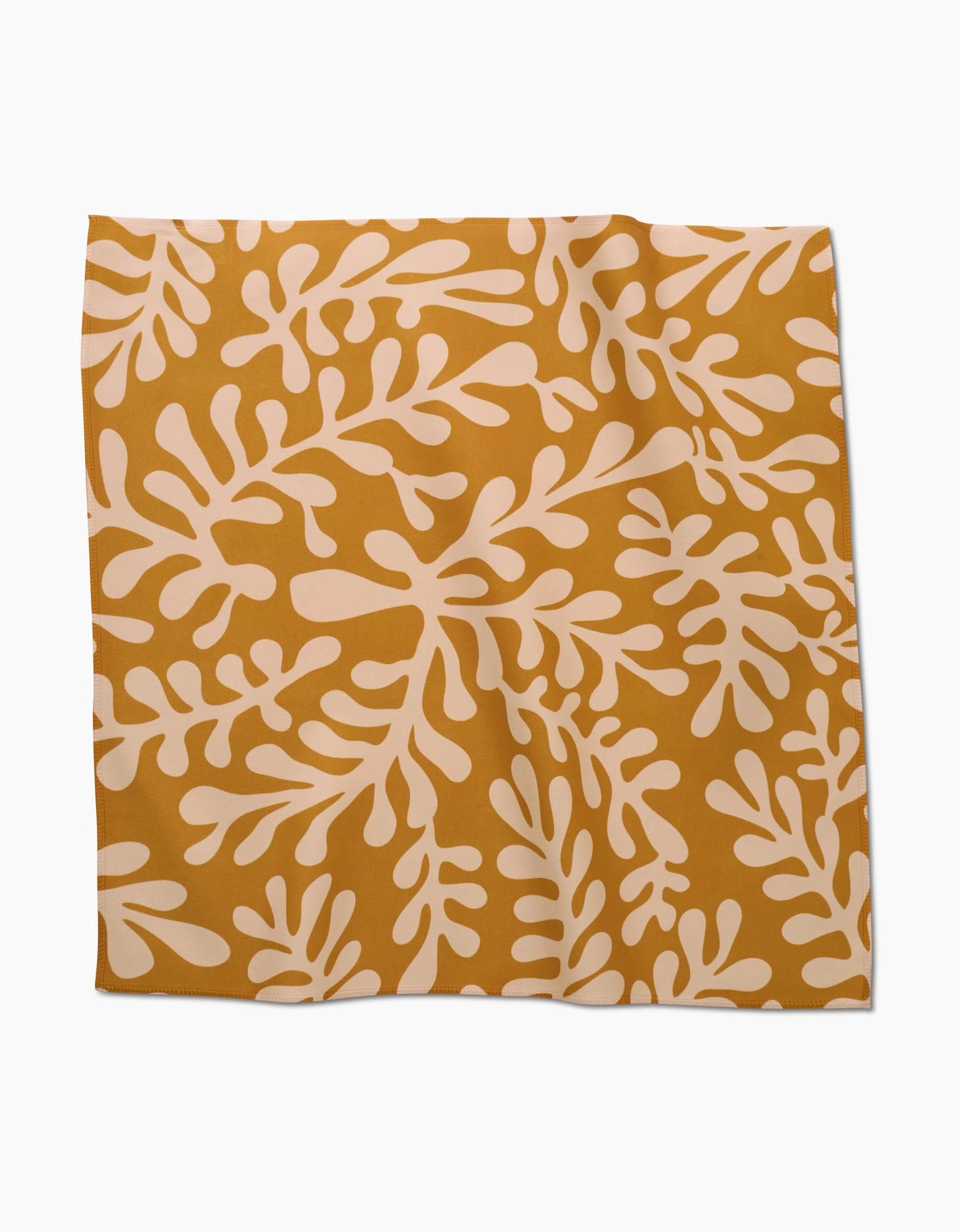 The GEOMETRY Golden Fall Dinner Napkin features an abstract white leaf pattern on a mustard yellow Geosuede fabric, shown square and flat against a white surface.
