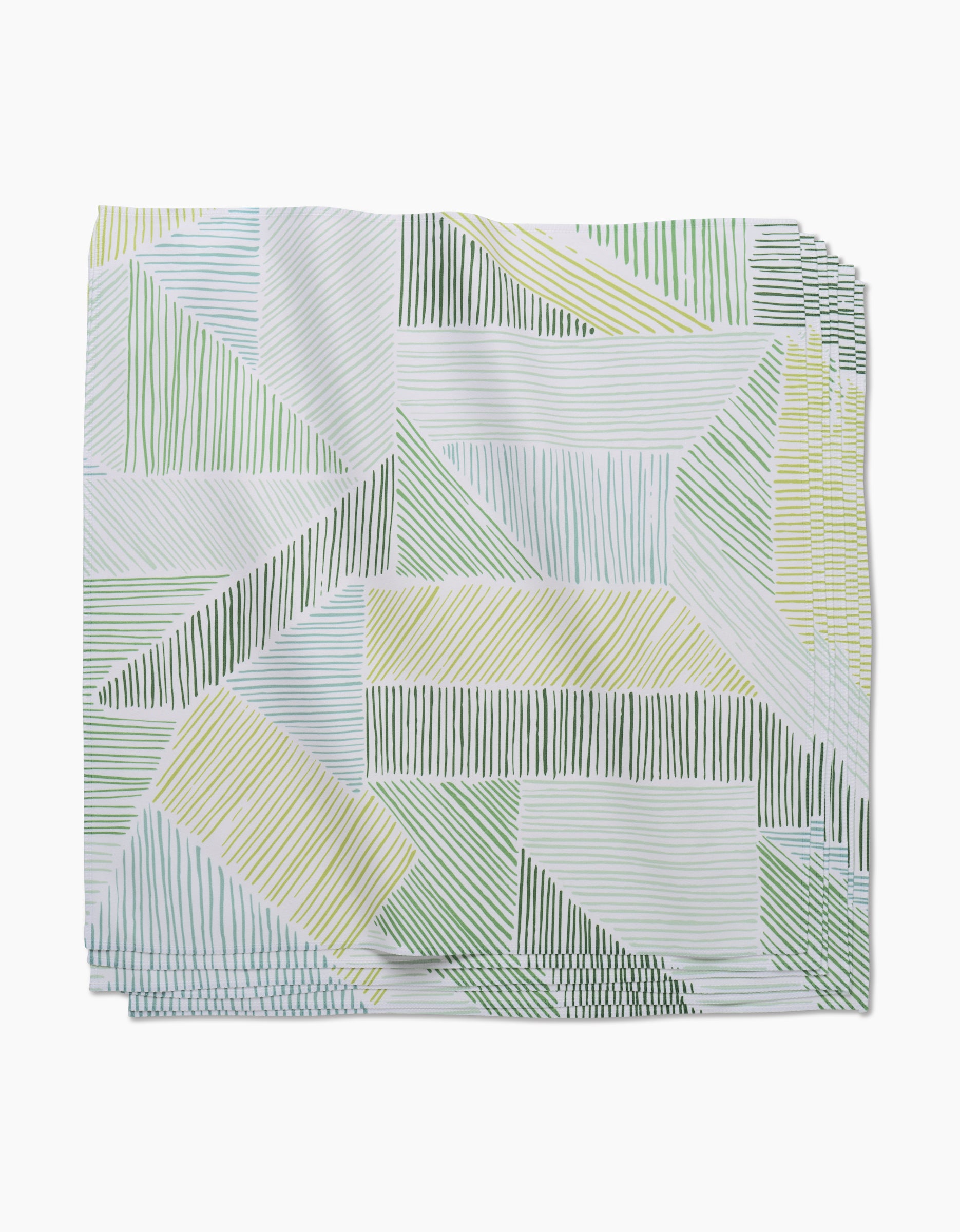 The Green Kites Dinner Napkin by GEOMETRY is crafted from Geosuede and features a geometric pattern of green, yellow, and blue lines on a white background.