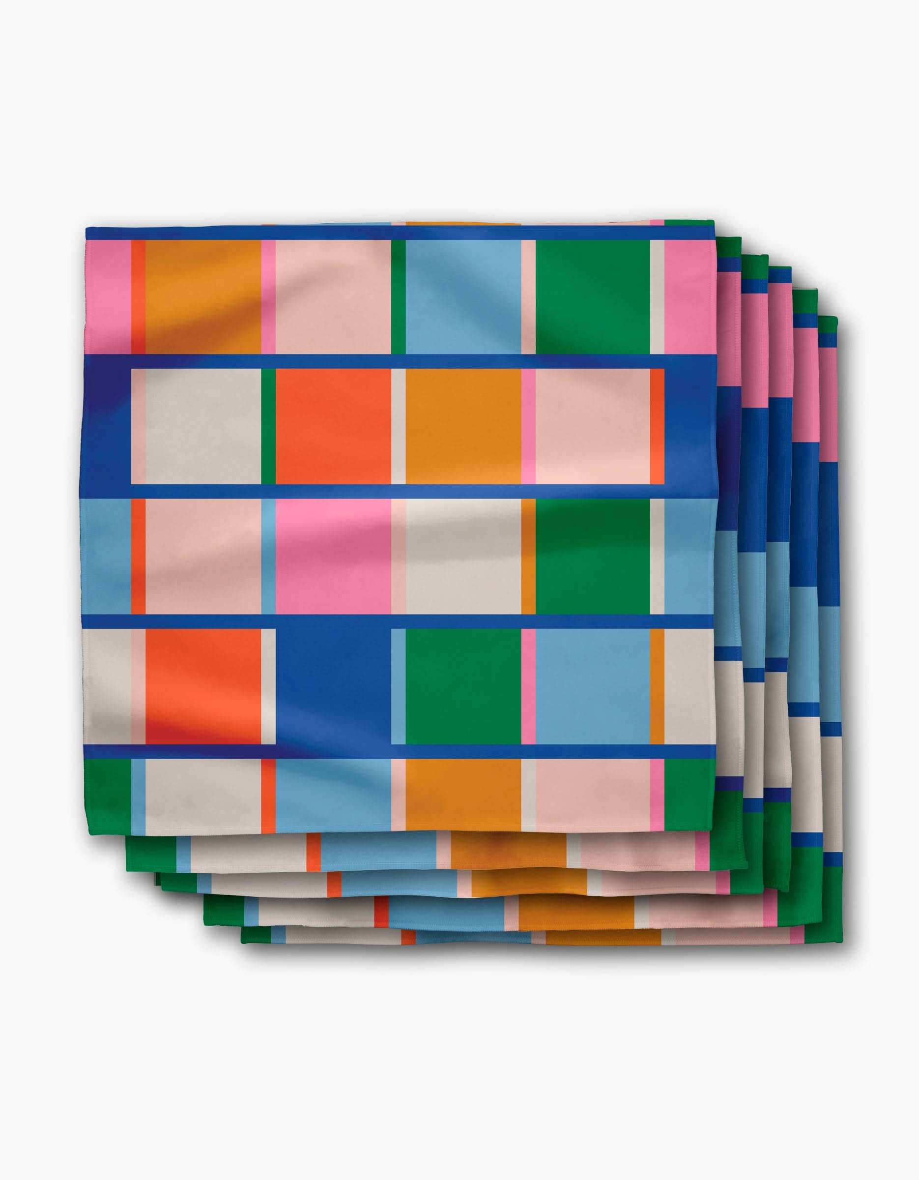 Set of four Grid dinner napkins by Jennifer Bouron, featuring a vibrant geometric pattern in blue, pink, orange, green, beige, and white on Geosuede fabric made from post-consumer recycled materials.