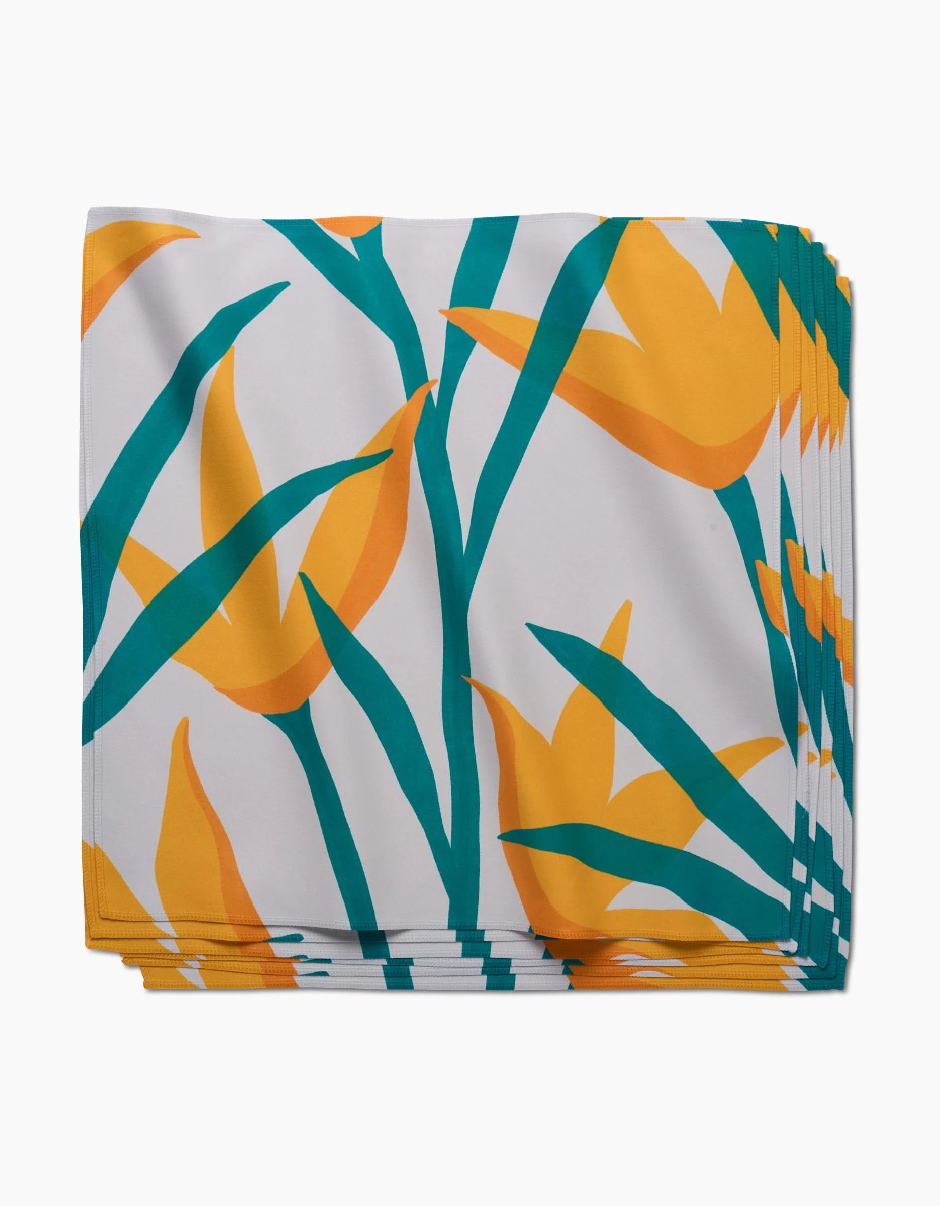 GEOMETRYs Growth dinner napkins feature a bold tropical print with yellow and orange flowers and green leaves on a white background.