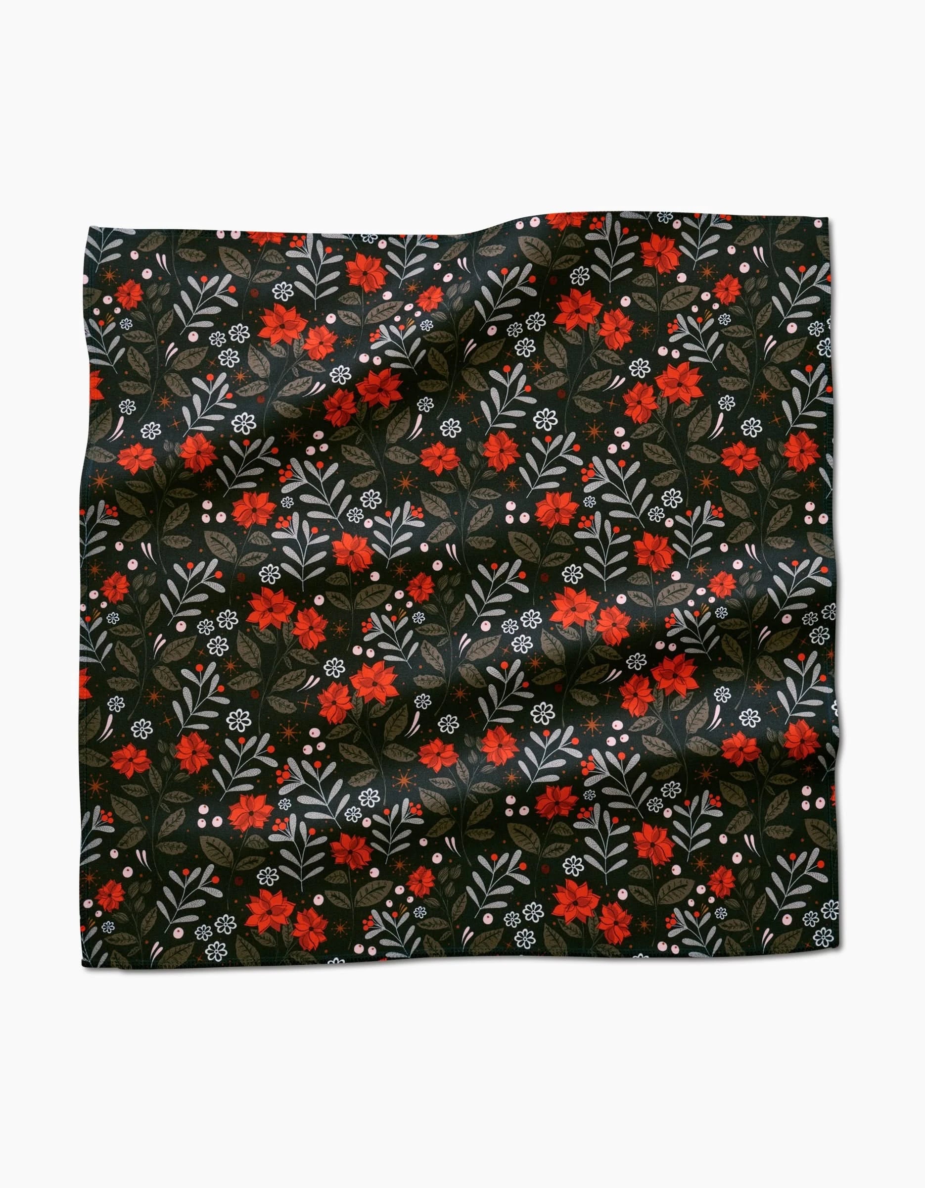 The Holiday Floral reusable napkin by Charlie Rowan Designs features red and white flowers, green leaves, and small branches on a black background—ideal as an eco-friendly dinner napkin for any festive table setting.