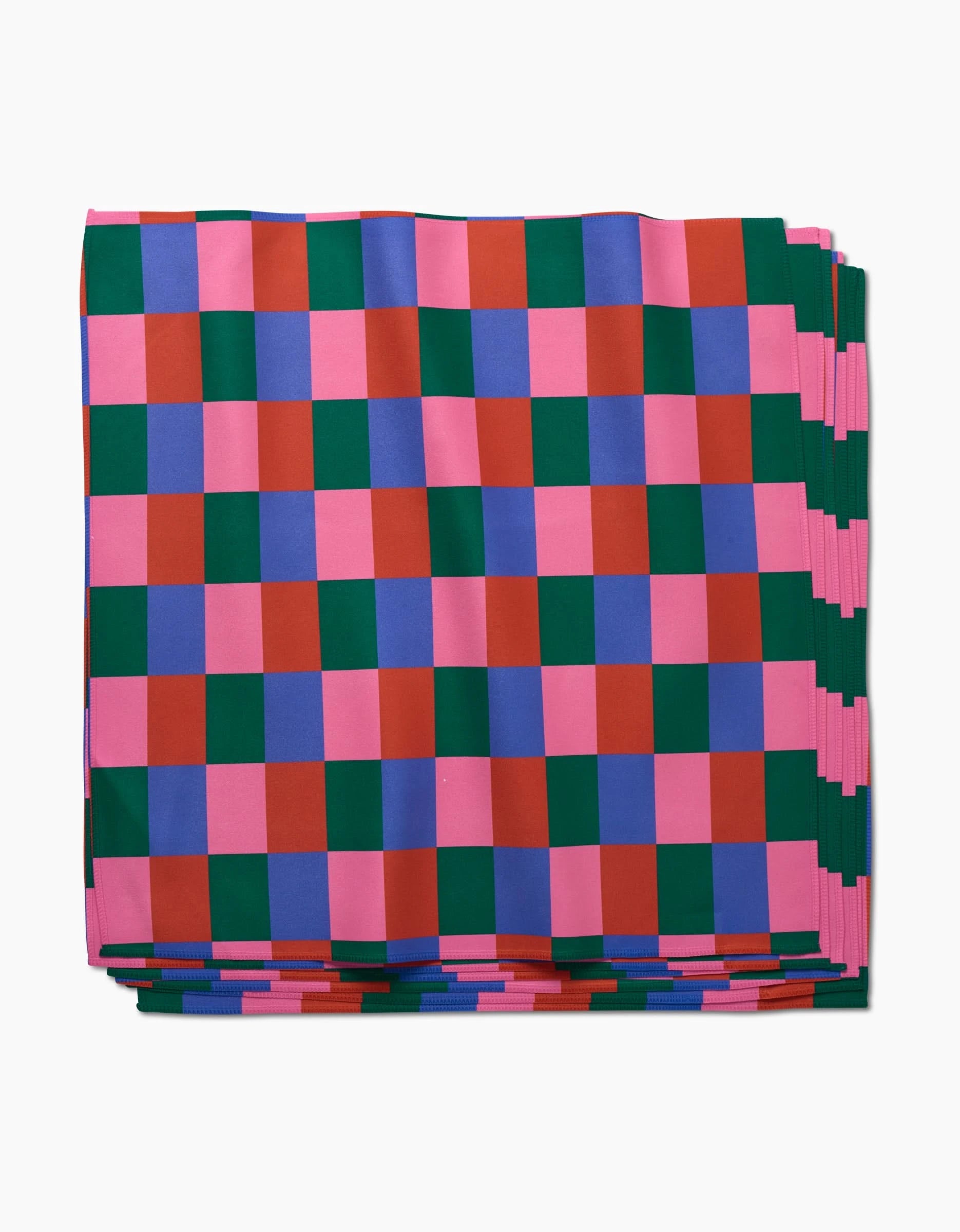 The Holiday Patchwork Dinner Napkin Set by Laura Supnik features a folded, checkered pattern in pink, red, green, and blue squares, neatly stacked against a white background.