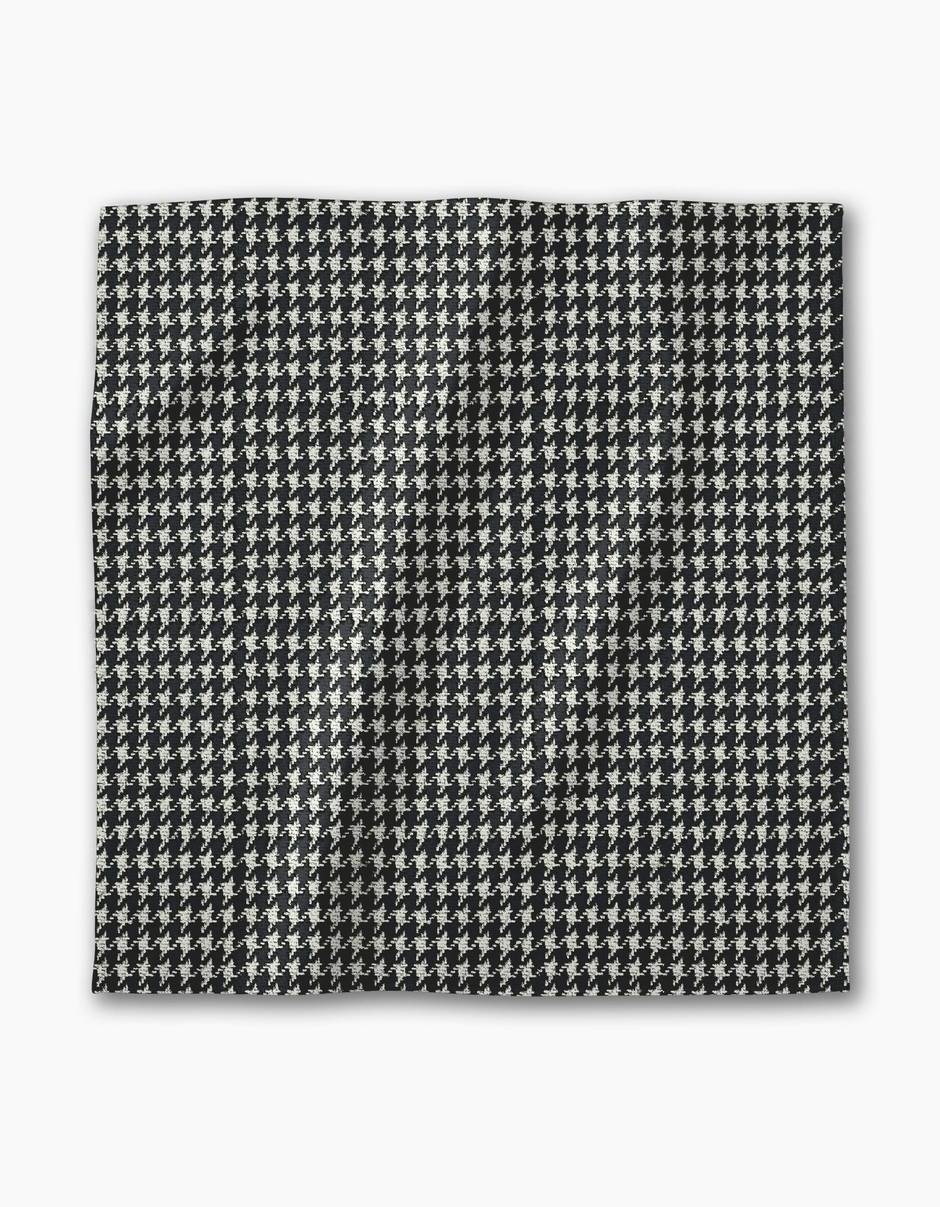 The Geometry Houndstooth Black rectangular fabric features a black and white houndstooth pattern with a slightly wrinkled texture, displayed on a white background—ideal for creating chic reusable napkins.