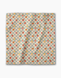 The Italian Summer Grid by Geometry is a square Geosuede fabric in light beige, featuring a blue diamond grid pattern with scattered red cherries and yellow flowers.