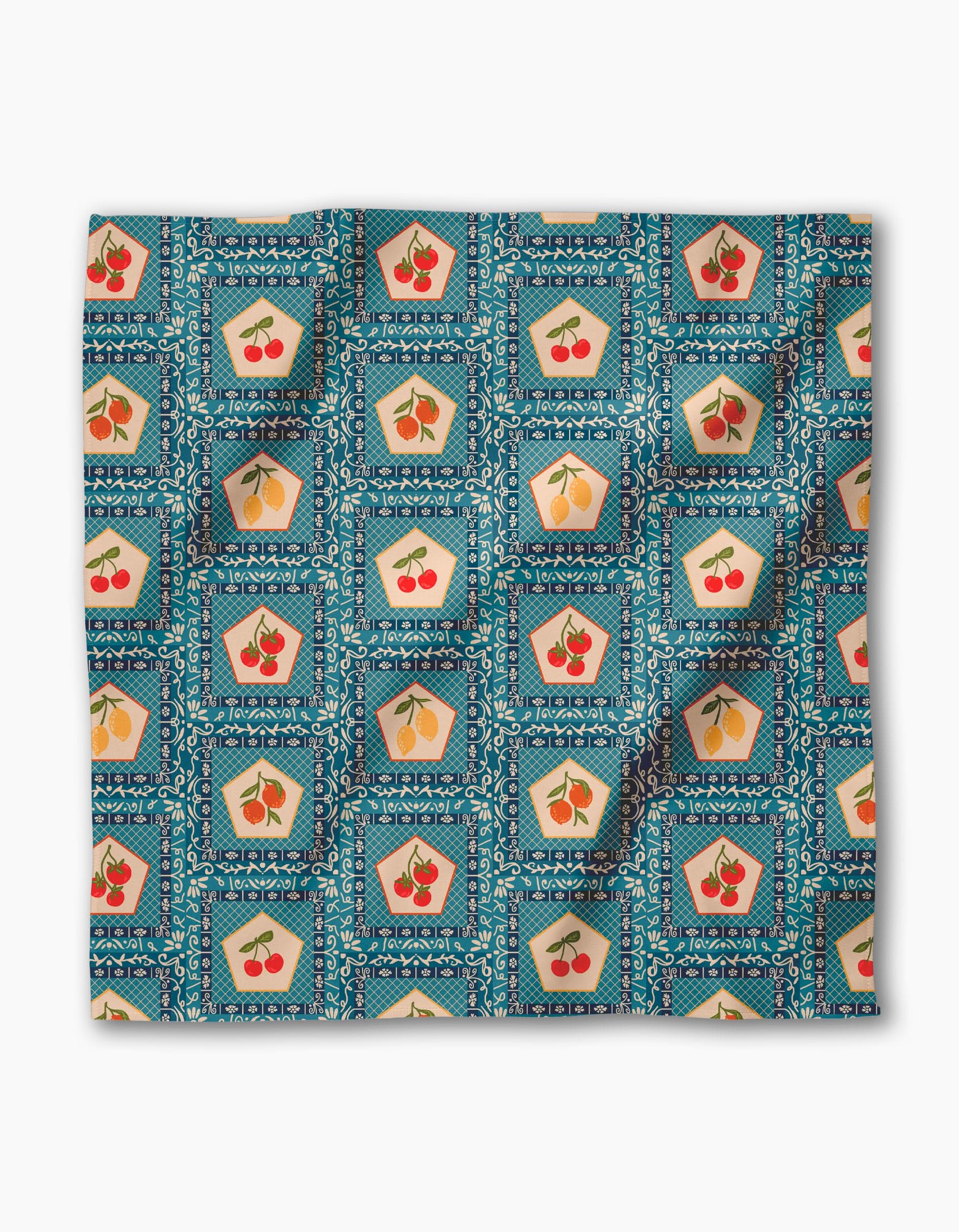 The Italian Tiles Dinner Napkin Set by Geometry features a blue Geosuede fabric with repeating squares, each displaying red cherries or yellow pears. Its vintage geometric style is finished with small decorative border details.