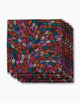 The Rachel Parker Jewel Leaf Swirl dinner napkin features a folded square cloth with vibrant red, orange, pink, purple, and cream leaves swirling on black—an elegant, eco-friendly addition to your napkins collection.