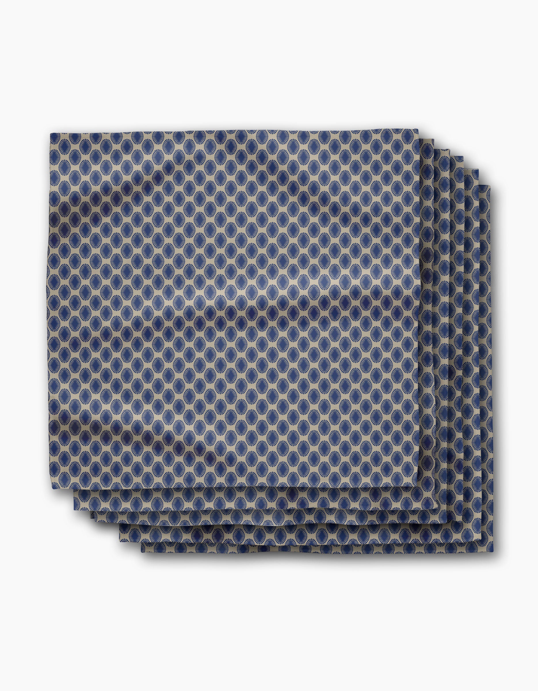 The Lagoon pocket square by Geometry features a blue and gold repeating circular geometric pattern, neatly folded and displayed on a white background.