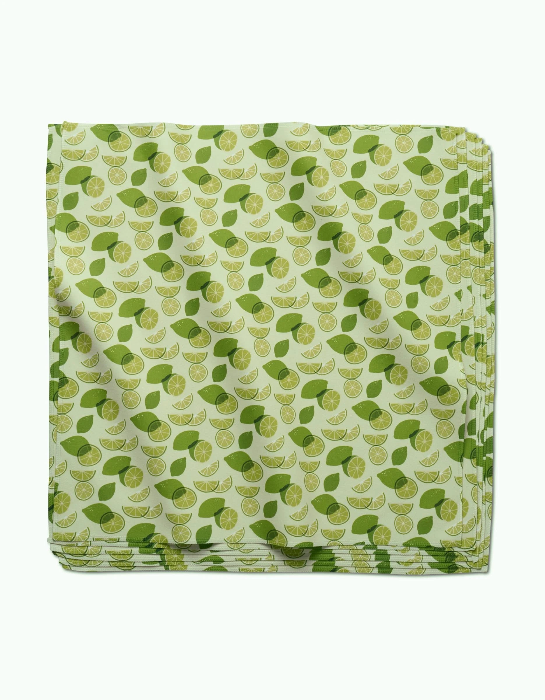 The GEOMETRY Limes napkin set features folded light green geosuede dinner napkins with a scattered lime wedge and green leaf pattern.