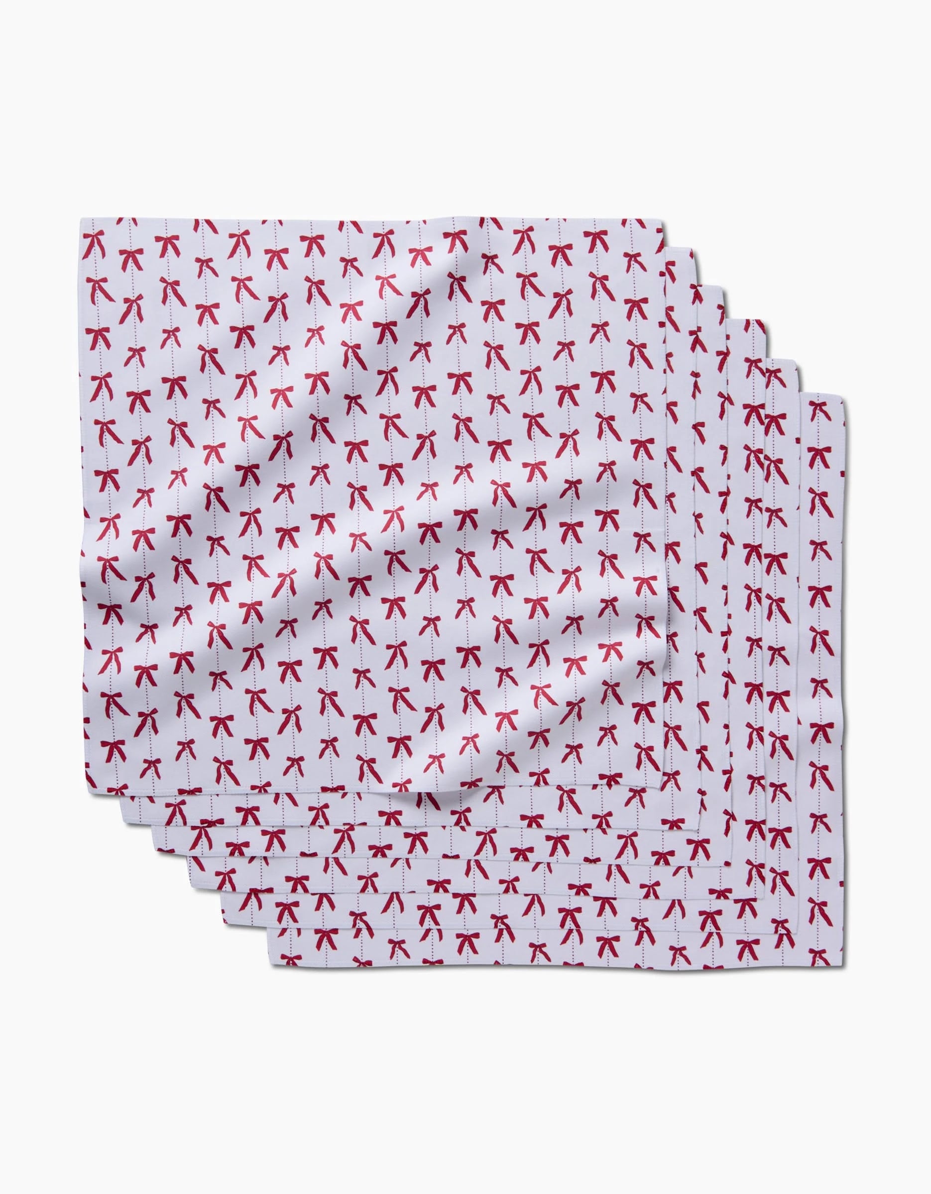 The Little Bows And Pearls dinner napkin set by Hufton Studio features white cloth napkins made from recycled materials, with a repeated small red AK-47 rifle motif arranged in rows on a plain white background.