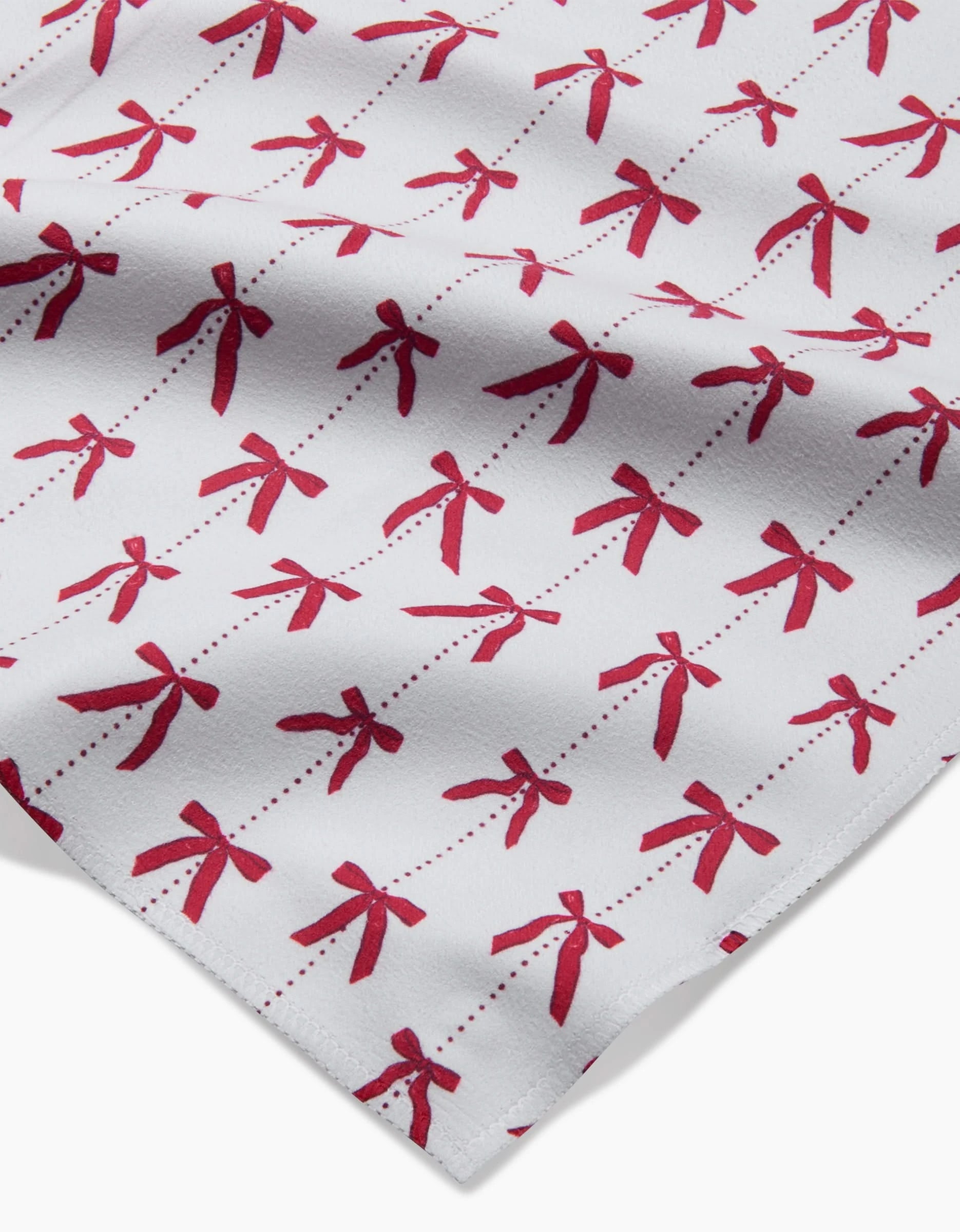 Little Bows And Pearls by Hufton Studio is a white Geosuede fabric with red bows connected by dotted lines. Soft and drapey, it’s ideal for creating an elegant dinner napkin set.