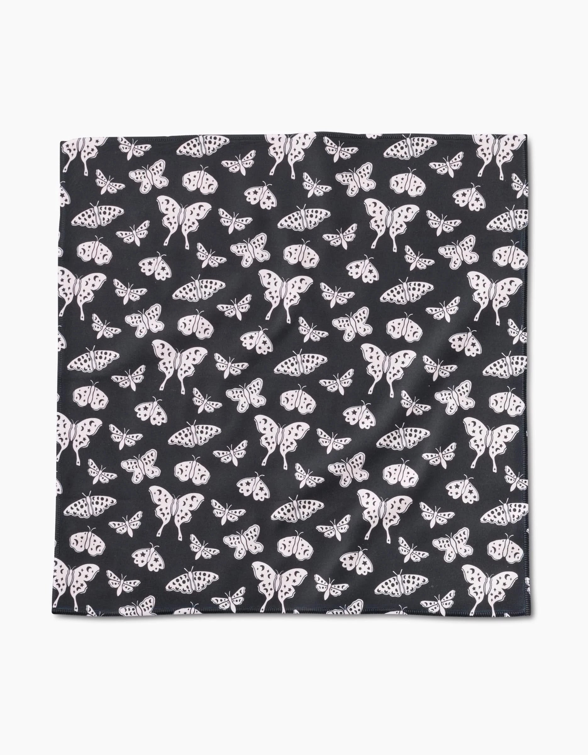 The Kayla Ann Lunar Moths Black Dinner Napkin Set features a square Geosuede fabric in black, patterned with light-colored lunar moths of various sizes—an elegant, recycled choice for stylish dining.