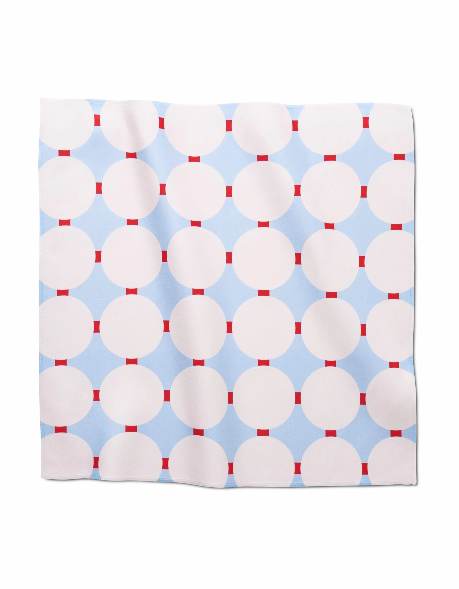 The Mist Blue Oasis dinner napkin by Happy Hemera features large white circles and red rectangles on a light blue background, crafted from soft Geosuede fabric made with recycled materials.