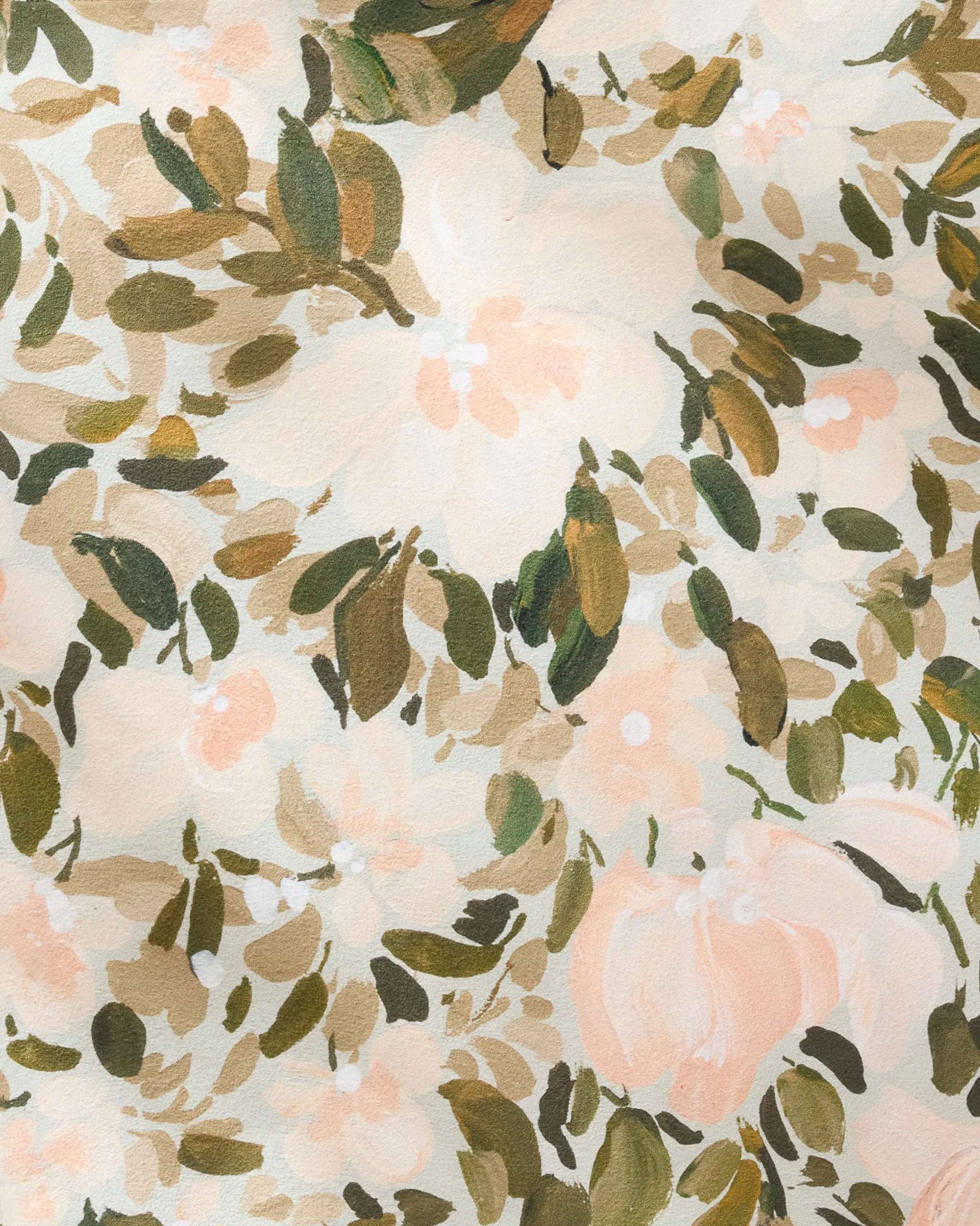 Close-up of Painted Blossoms by Anee Shah—a cream fabric with green leaves and light pink flowers in a watercolor, hand-painted style. Perfect for creating elegant reusable dinner napkins.