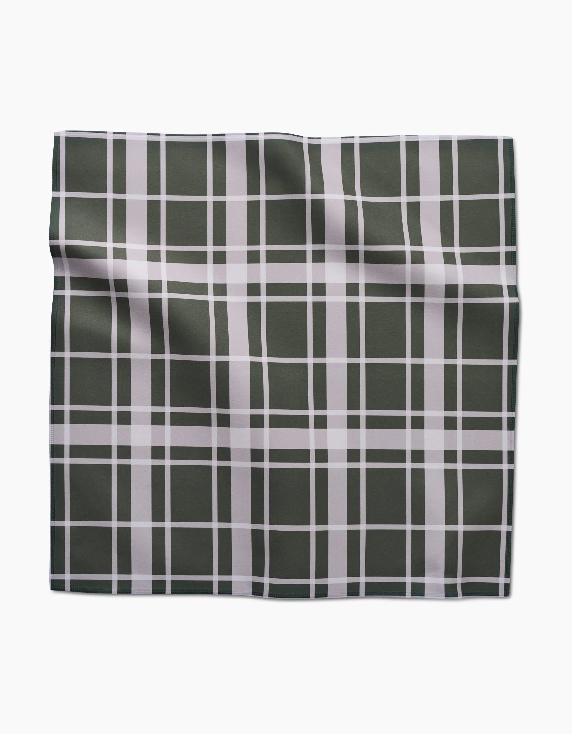 The Aubrey Fairchild Picnic Time Green Dinner Napkin Set features Geosuede fabric with a green background and white plaid pattern, slightly wrinkled, displayed on a plain white surface.