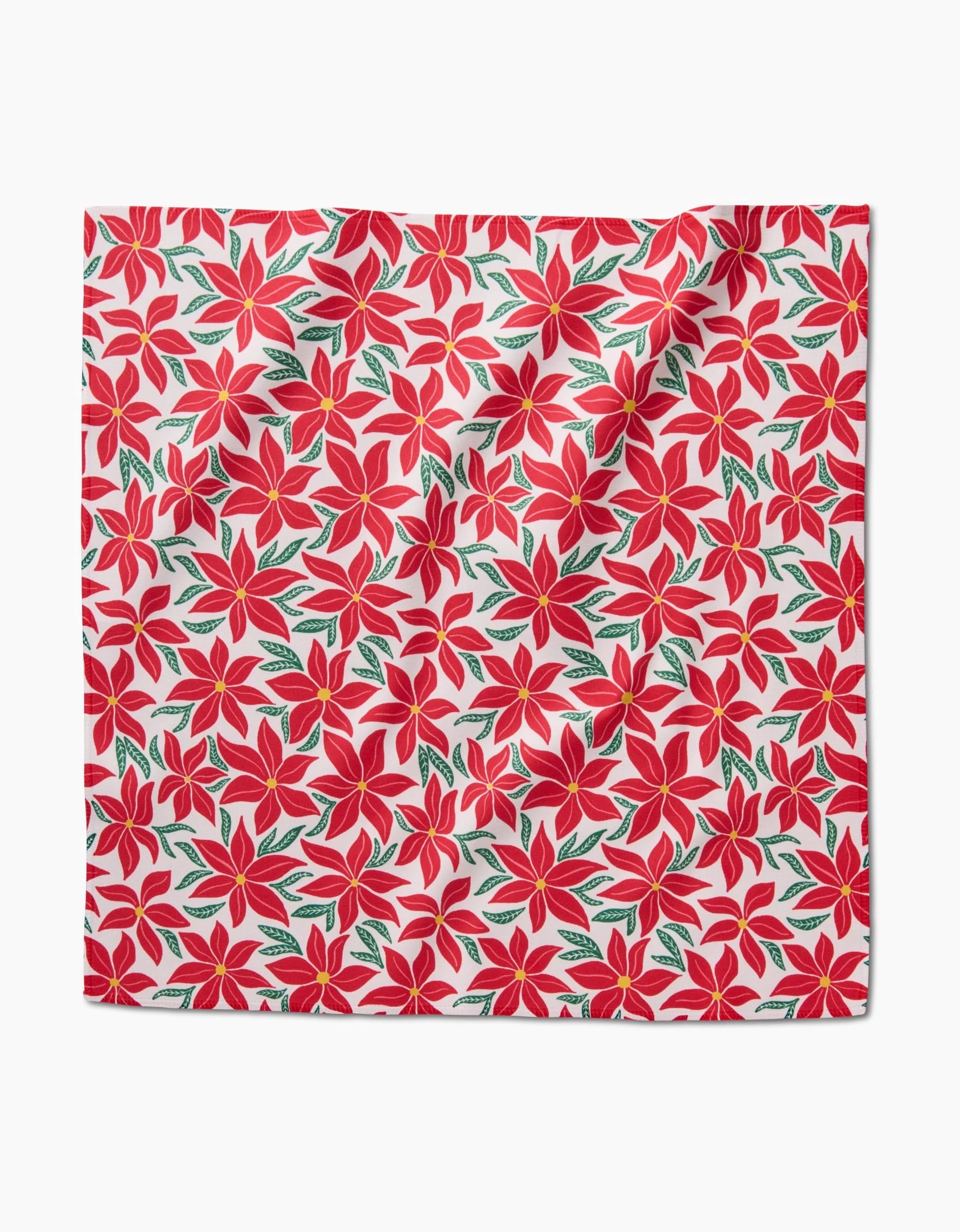The Kayla Ann Poinsettia Party dinner napkin set features red poinsettias with green leaves on white, crafted from recycled materials and showing slight folds for an elegant touch.