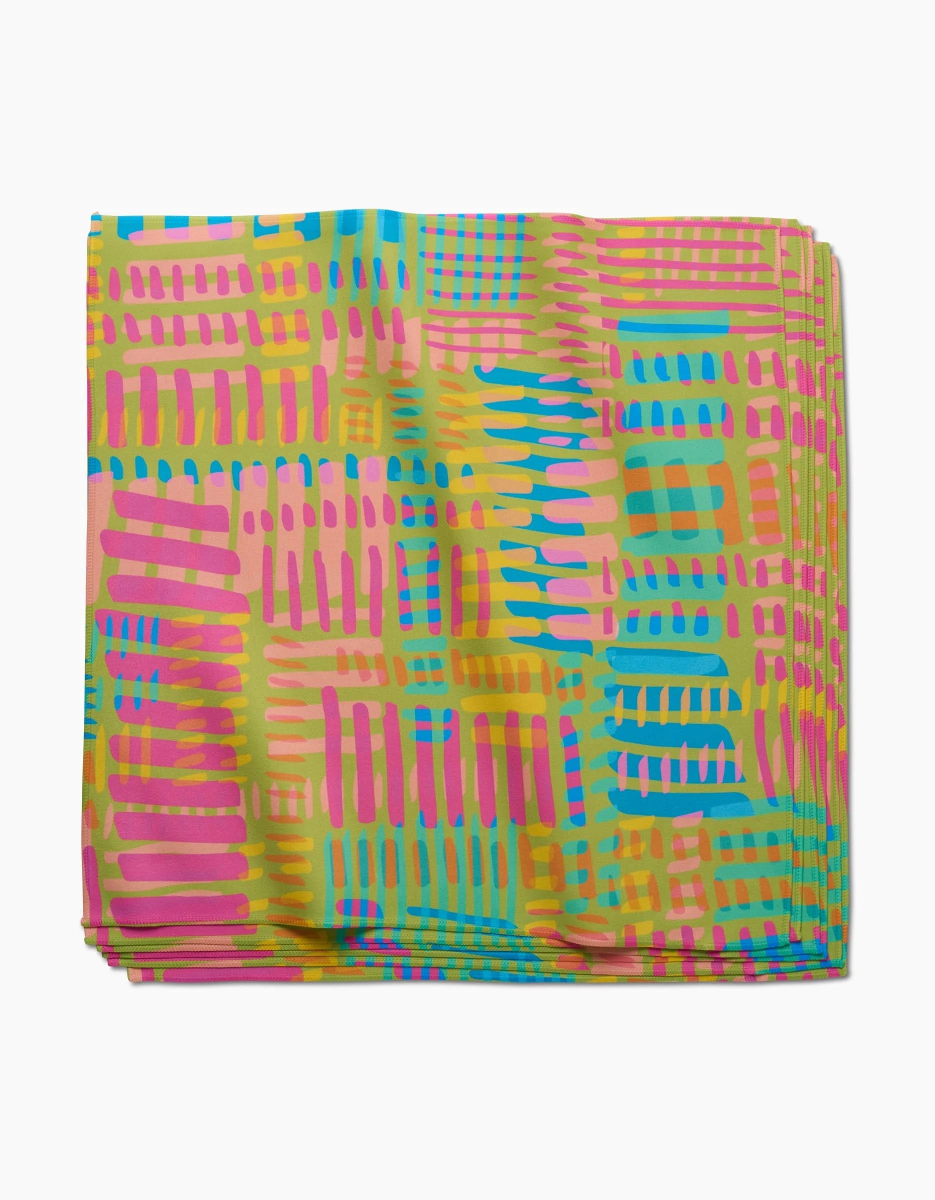 The Sareka Unique Positive Vibes dinner napkin is made of folded Geosuede fabric with a vibrant abstract pattern of pink, yellow, blue, and green brush strokes and grid shapes on a light background.