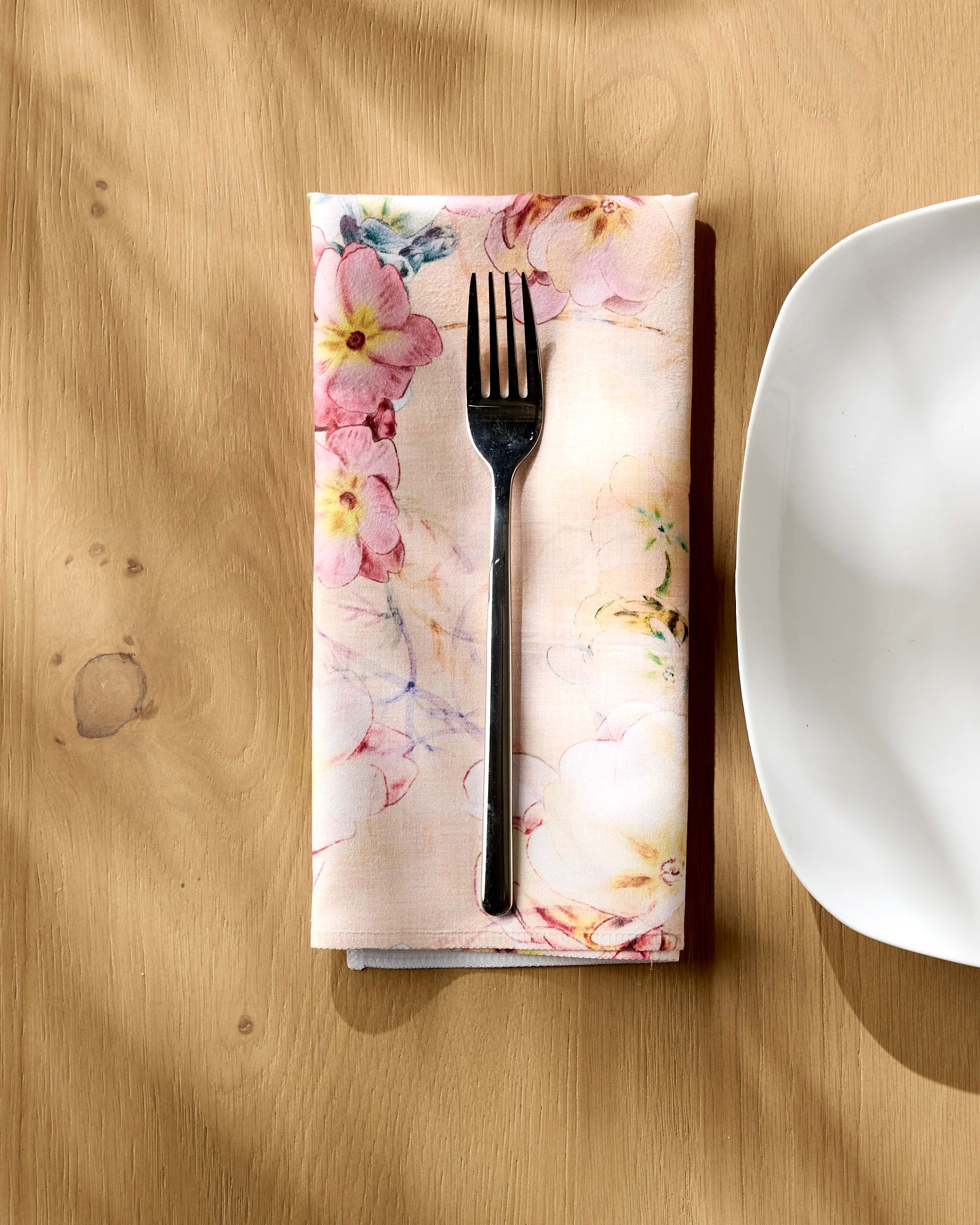 A fork on a Pascale Dilger Primroses Geosuede fabric dinner napkin set.