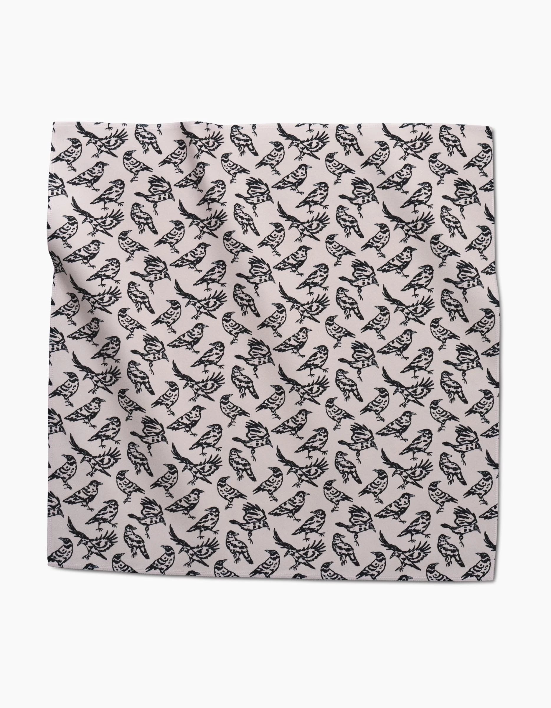 Raven by Kayla Ann: a square absorbent napkin featuring a repeating black owl pattern on a light background. The stylized owls all face one way. Slight creases and folds in the fabric make it perfect for dinner napkin sets.