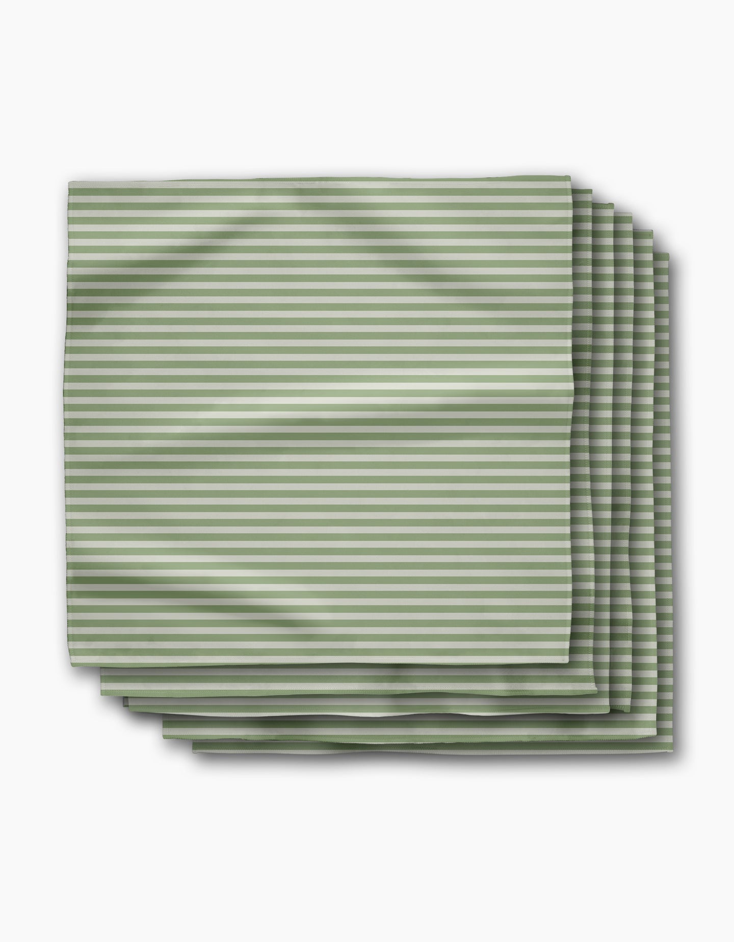 Geometry’s Seagrass Dinner Napkin Set includes four neatly folded cloth napkins made from recycled materials, featuring thin green and white horizontal stripes on a white background.