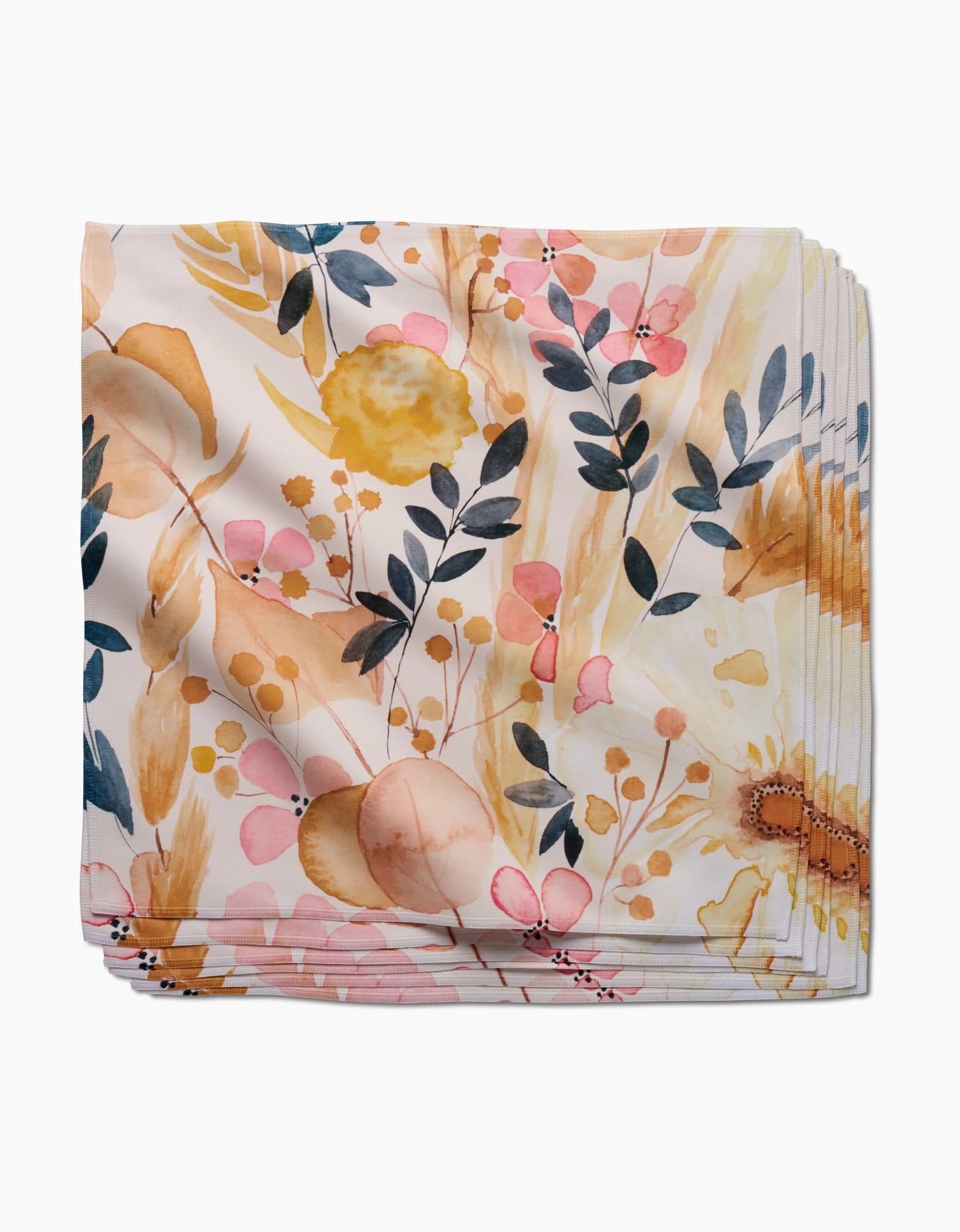 The Sleepy Fields napkin by GEOMETRY features a watercolor floral pattern in yellow, pink, orange, and green on white Geosuede fabric.