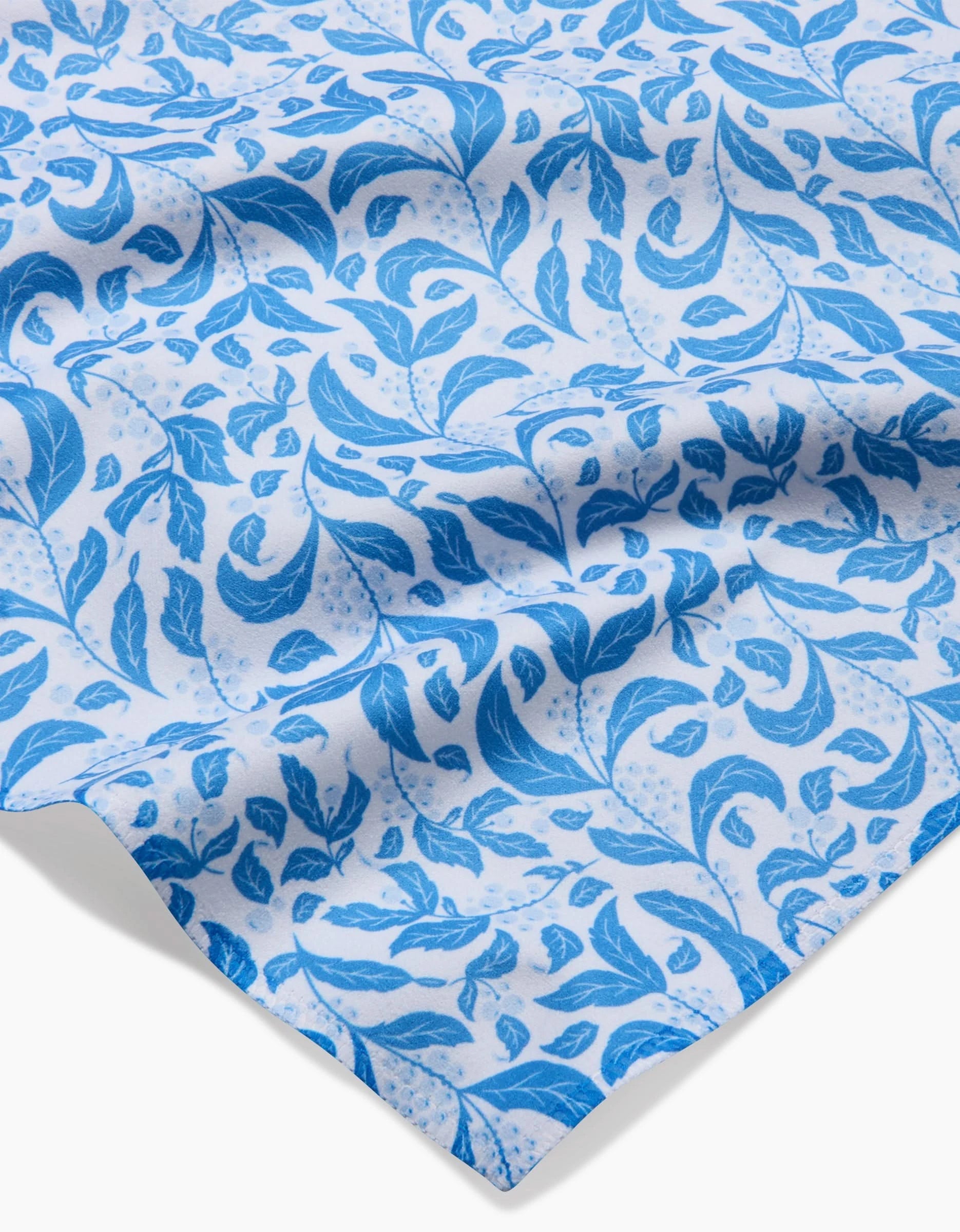 The Snowberry fabric by Danelys Sidron features a blue leafy vine pattern on white, with varied leaf shapes and curling stems—ideal for absorbent napkins in your Dinner Napkin Set.