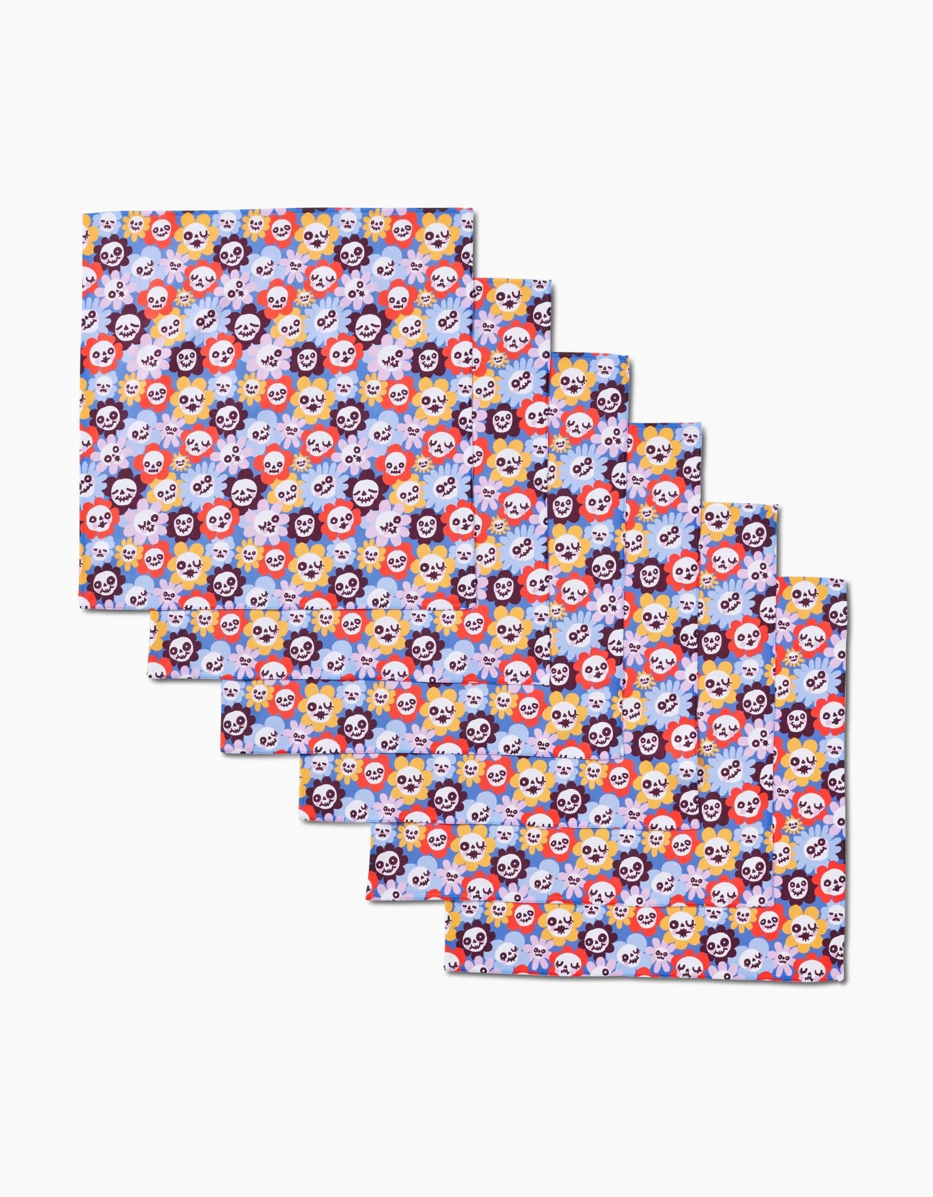 Six rectangular Spooky Bouquet fabric sheets by So Lazo, arranged in a staggered stack, each featuring colorful cartoon panda faces on pale blue—playful dinner napkins made from recycled materials.