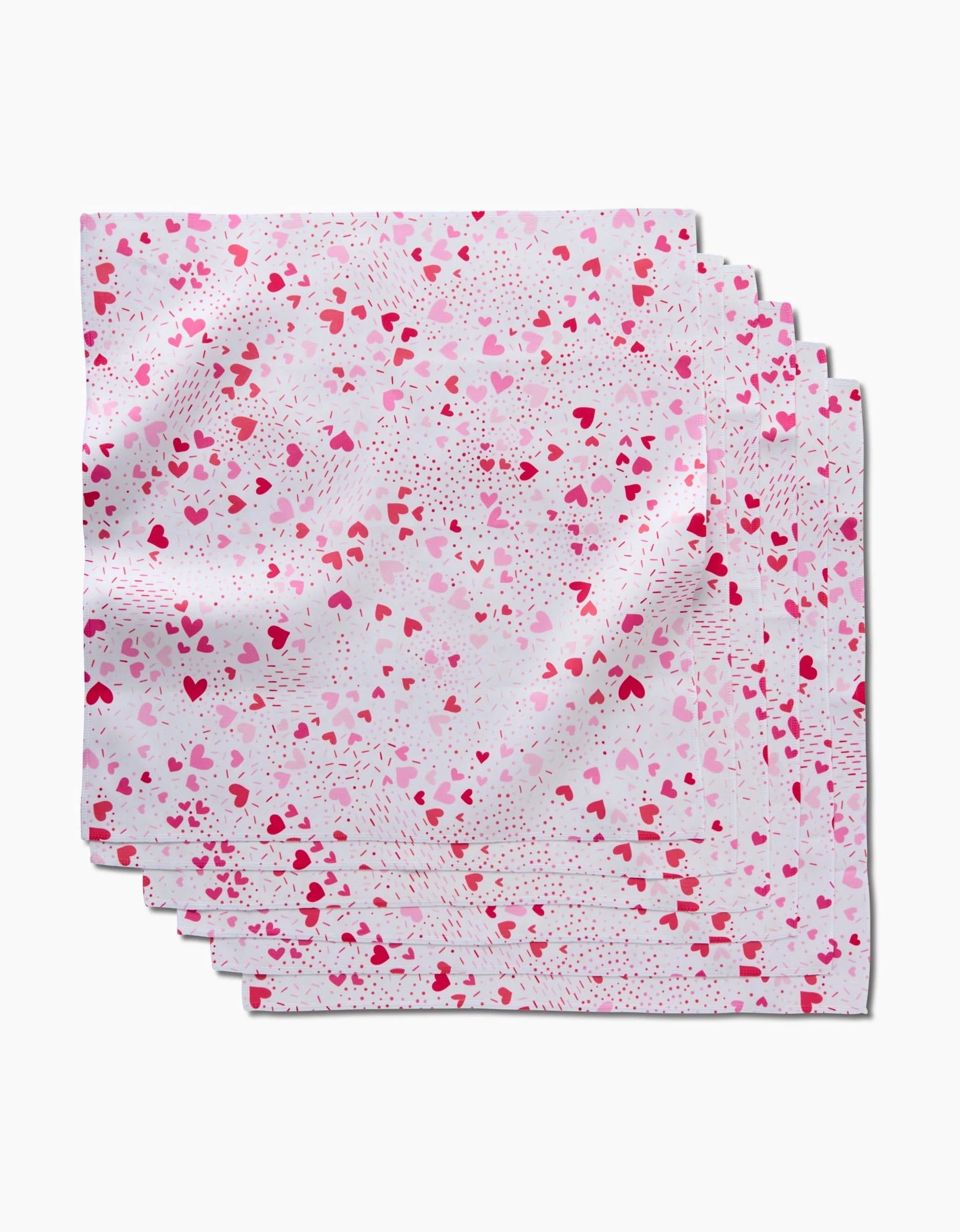 Six Sprinkled With Love napkins by Rebecca Bobko, featuring a pink and red heart pattern on white, are fanned out—perfect for bringing charm and eco-friendly style to your table setting.