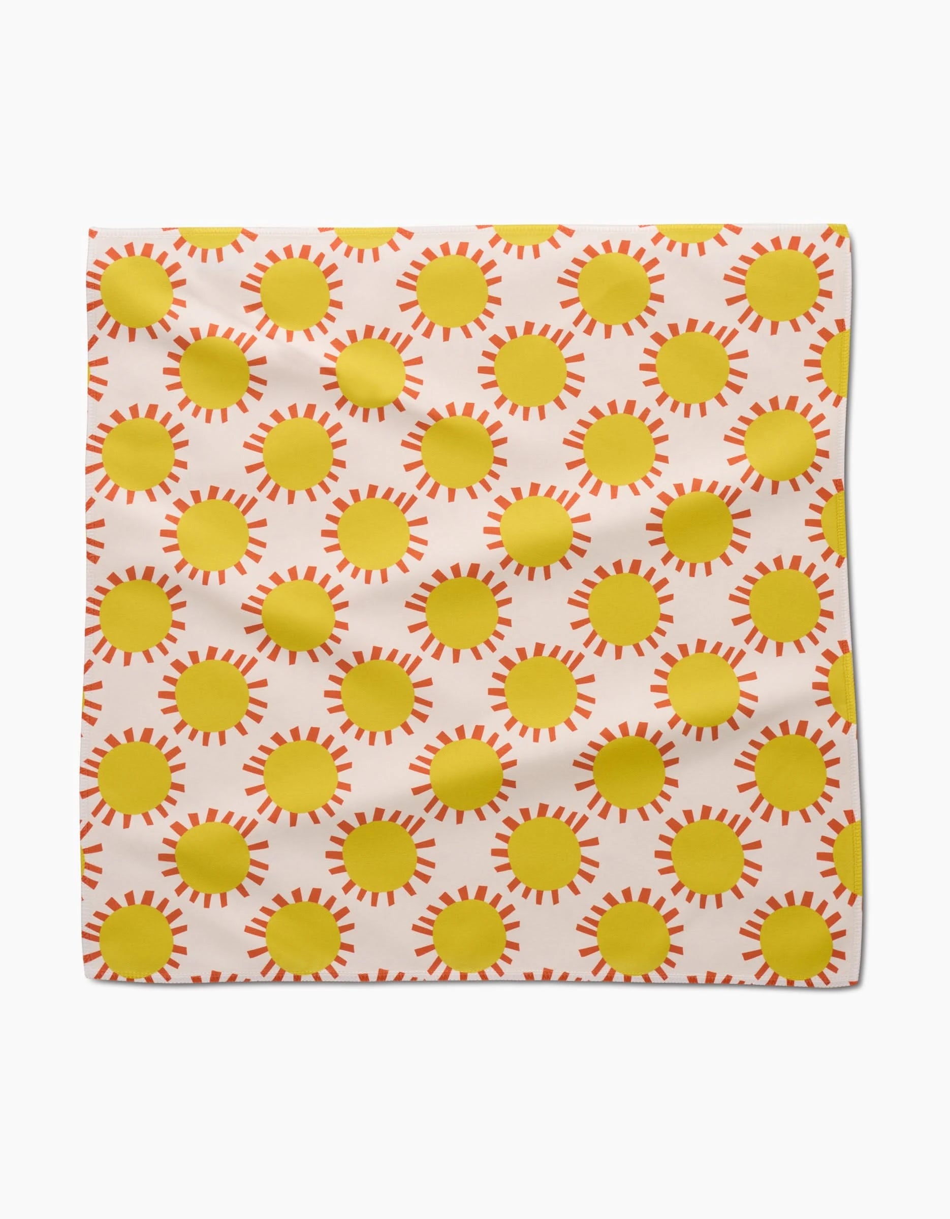 The Lizzie Clark Sunny Day square Dinner Napkin features a grid of yellow suns with orange rays on a white Geosuede fabric background, with a slightly wrinkled texture for added appeal.
