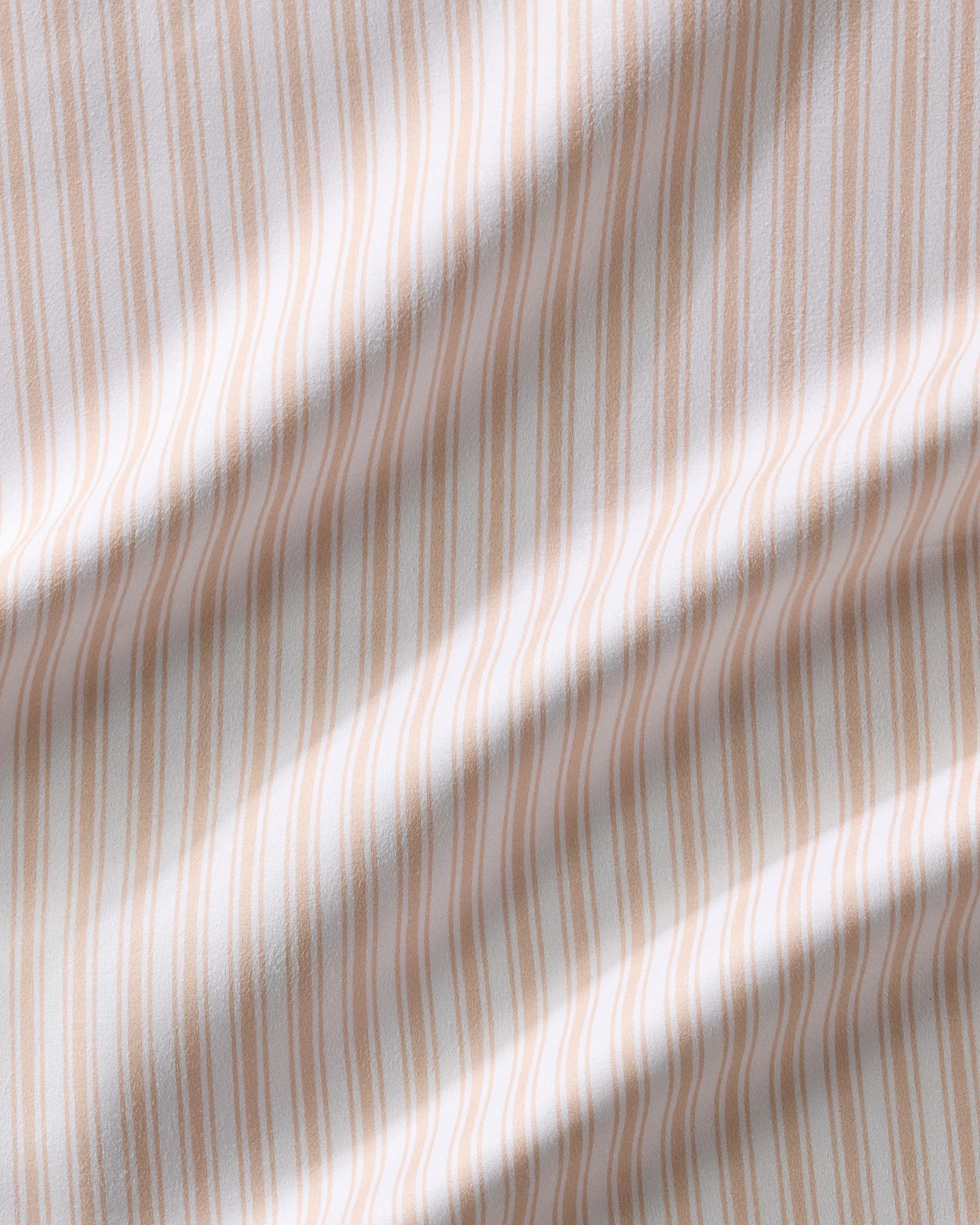 A close-up of Sweet Boho fabric by Hufton Studio, featuring vertical beige and white stripes with gentle ripples—ideal for stylish reusable table napkins to elevate your dining experience.
