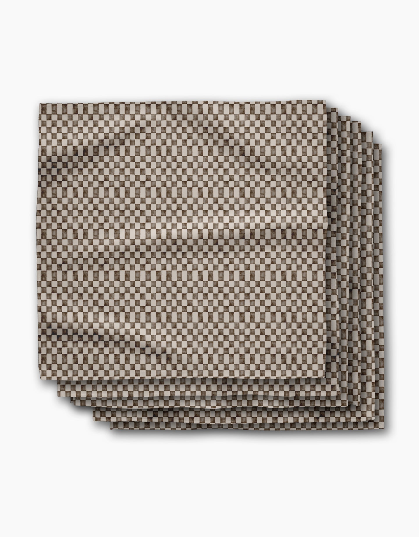 A set of four eco-friendly “Tavern” napkins by Geometry, neatly folded and displaying a small brown and white checkerboard pattern against a white background.