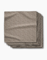 A set of four eco-friendly “Tavern” napkins by Geometry, neatly folded and displaying a small brown and white checkerboard pattern against a white background.