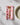 The Geometry Watercolor Dreaming eco-friendly napkin with a pink and red leaf pattern sits under a gold fork beside a beige plate on a white textured surface.