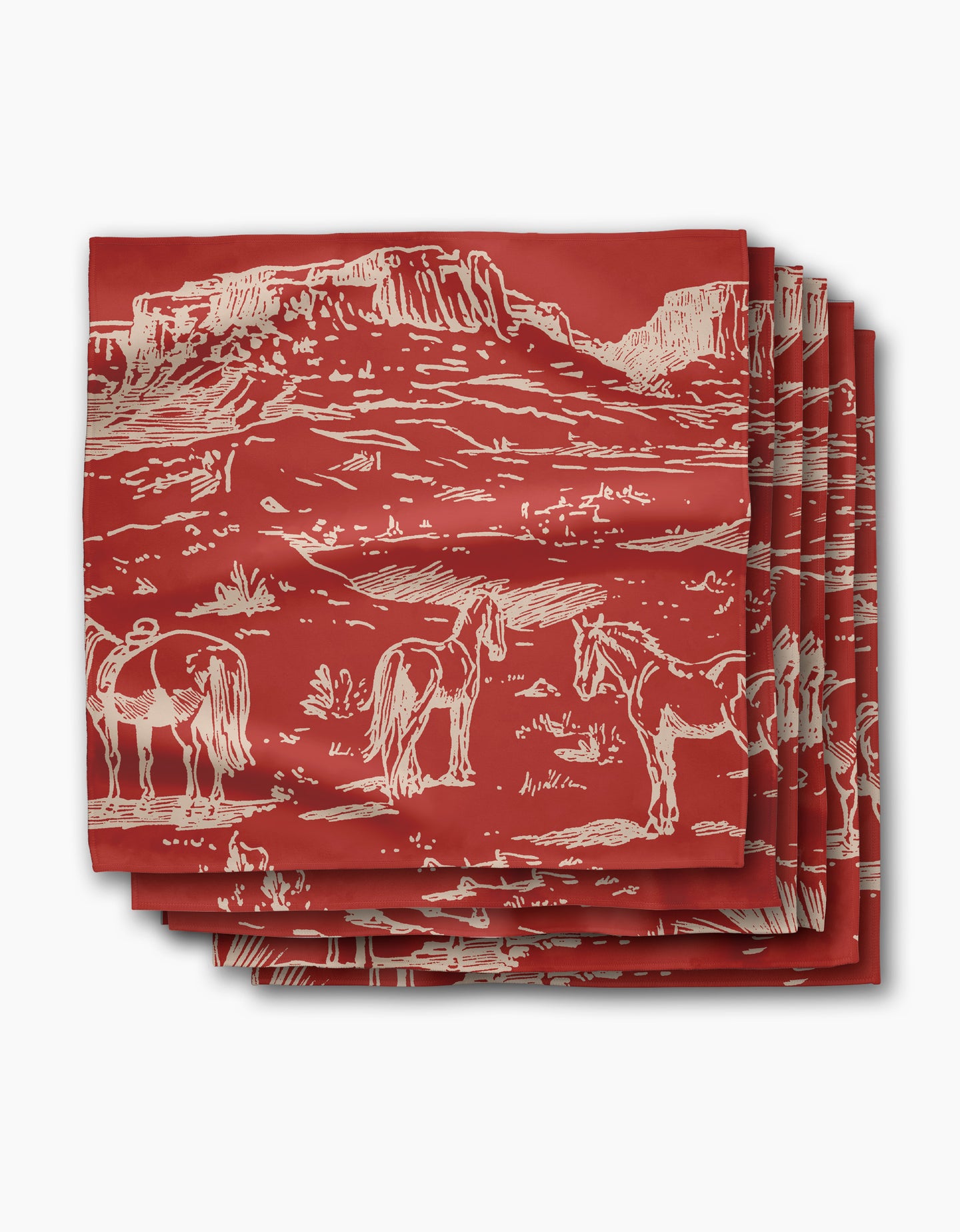 Geometry’s “Western Scene” napkin is a red, recycled dinner napkin featuring a white line drawing of mesas, horses, and desert plants. The eco-friendly napkins are stacked neatly with the design prominently displayed.