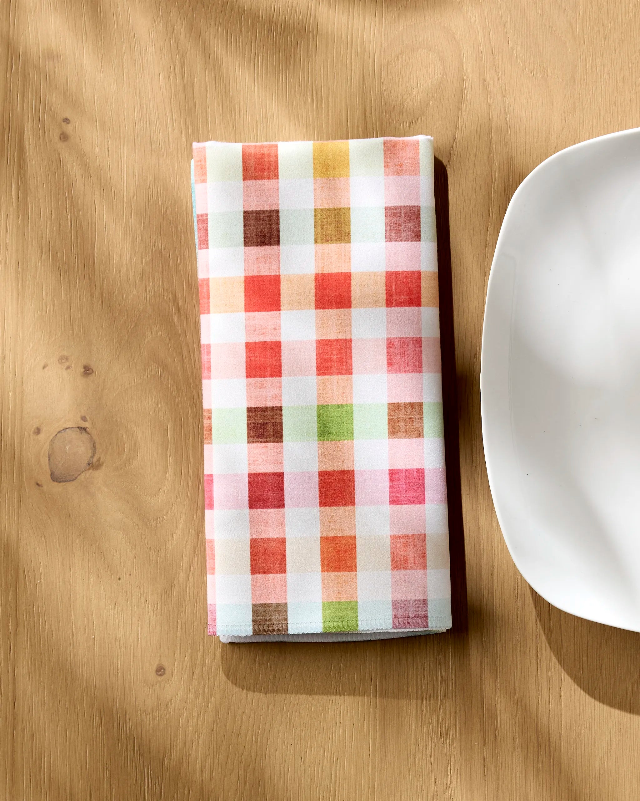 The Pascale Dilger Woven Spring Plaid napkin rests neatly on the table, adding a touch of sustainable elegance to your meal.