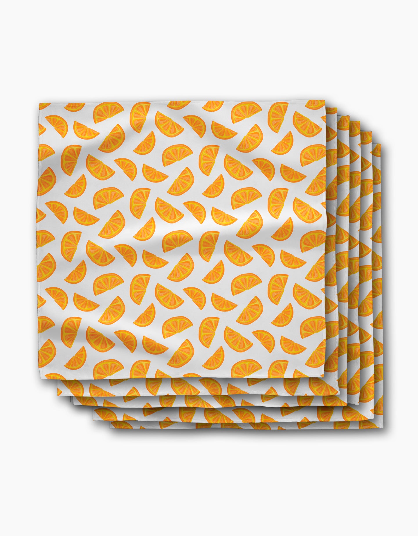 The Aubrey Fairchild Zesty Slice dinner napkins are made from Geosuede fabric and feature orange slice patterns scattered on a white background.