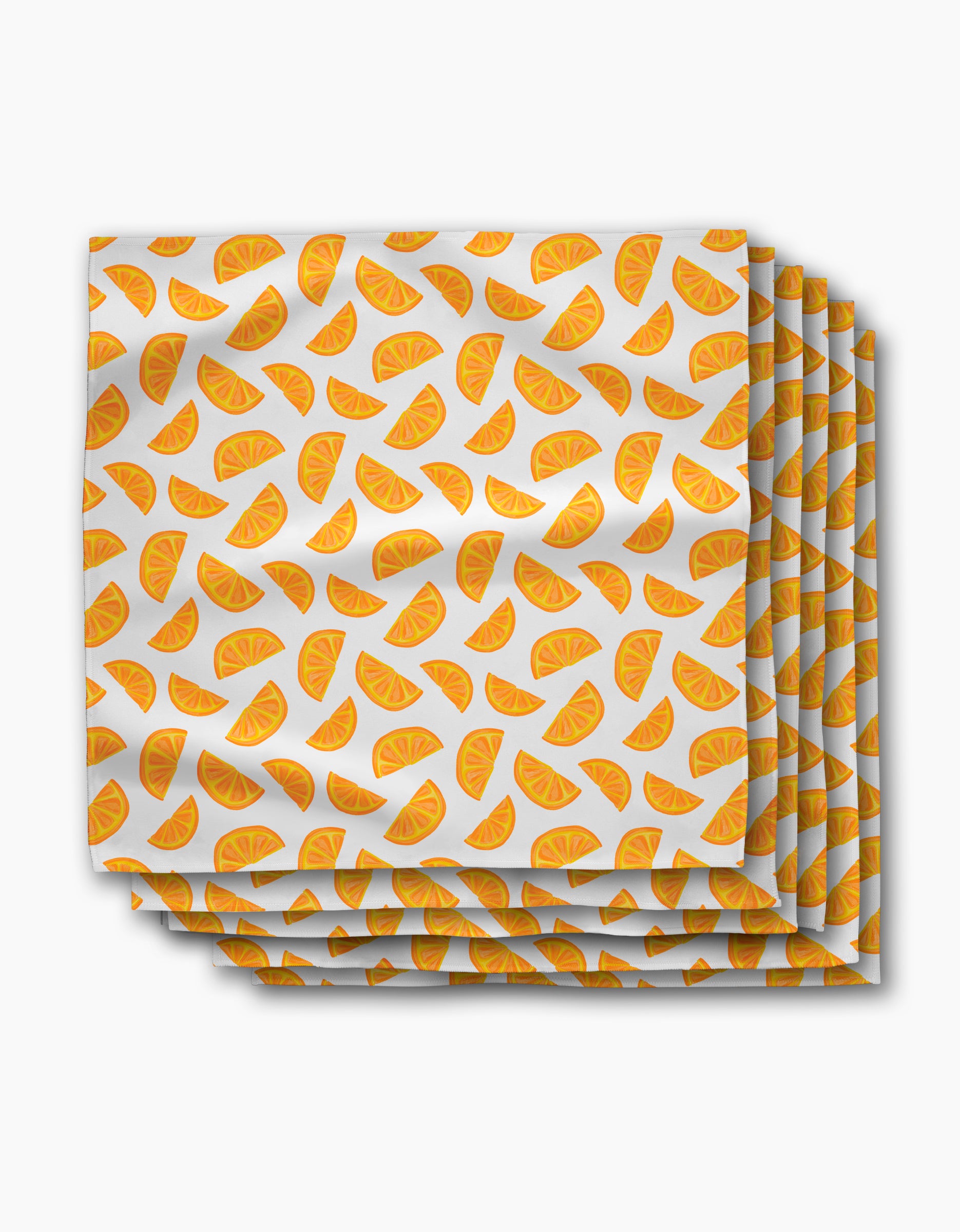 The Aubrey Fairchild Zesty Slice dinner napkins are made from Geosuede fabric and feature orange slice patterns scattered on a white background.