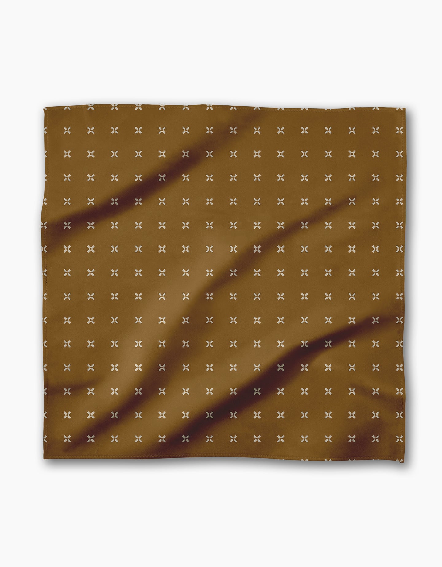 The Geometry Amber Stitch is a brown rectangular Geosuede cloth adorned with small white X patterns and subtle dark brown diagonal streaks.