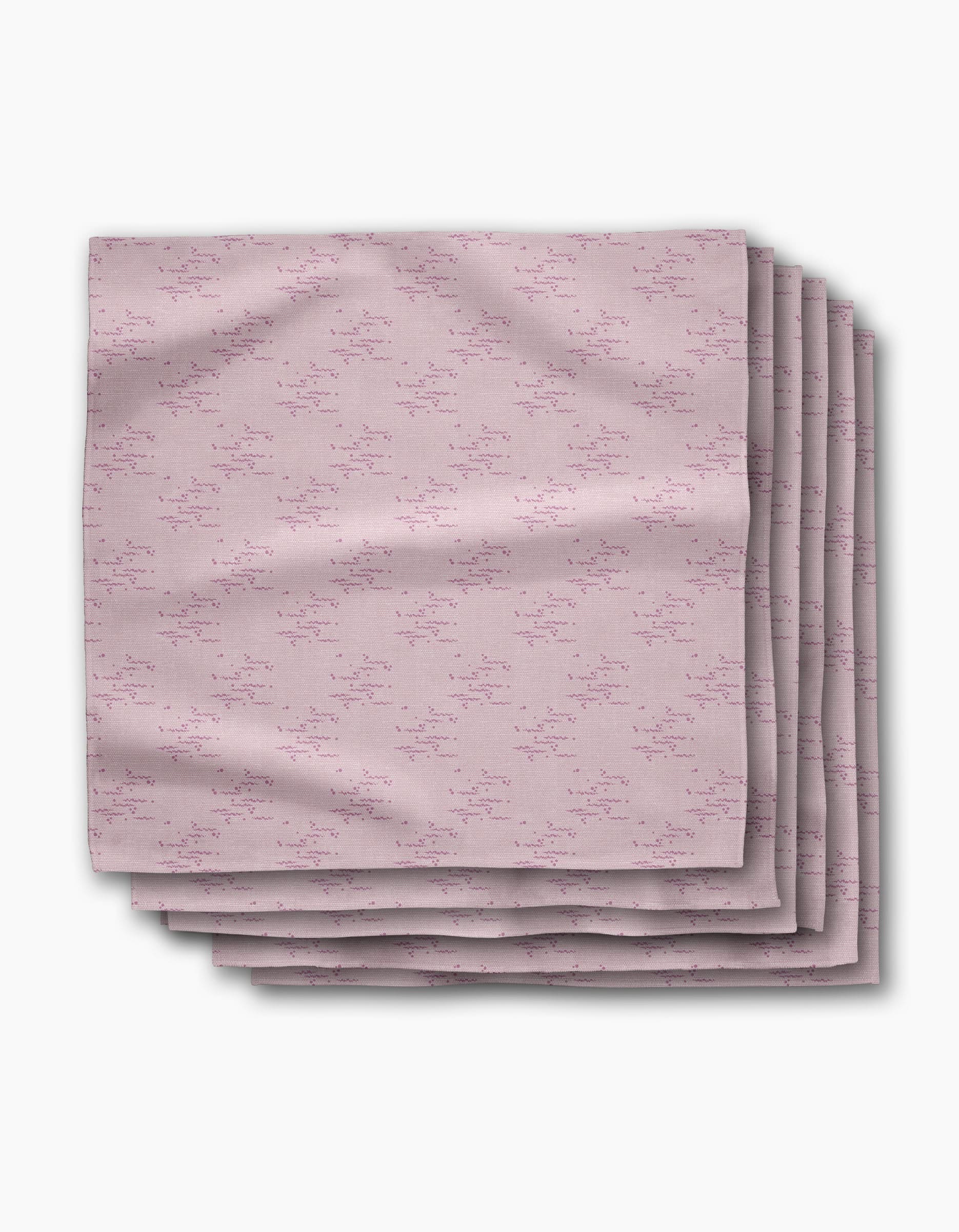 A stack of five Bubble Ditzy Dusty Rose reusable napkins by Geometry, featuring a subtle repeating pattern in dusty rose tones, is displayed folded on a white background.
