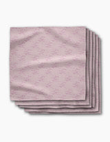 A stack of five Bubble Ditzy Dusty Rose reusable napkins by Geometry, featuring a subtle repeating pattern in dusty rose tones, is displayed folded on a white background.