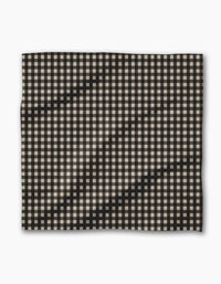 Geometry’s Charcoal Gingham features a black and white checkered fabric with visible waves and folds, set against a plain white background—perfect for your recycled Dinner Napkin Set.