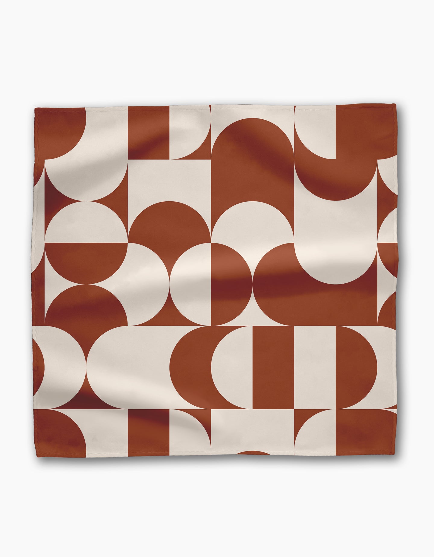 The Geometry Circle Playground is a rectangular reusable cloth napkin with a modern rust-orange and white geometric pattern featuring repeating semicircles, rectangles, and arches.