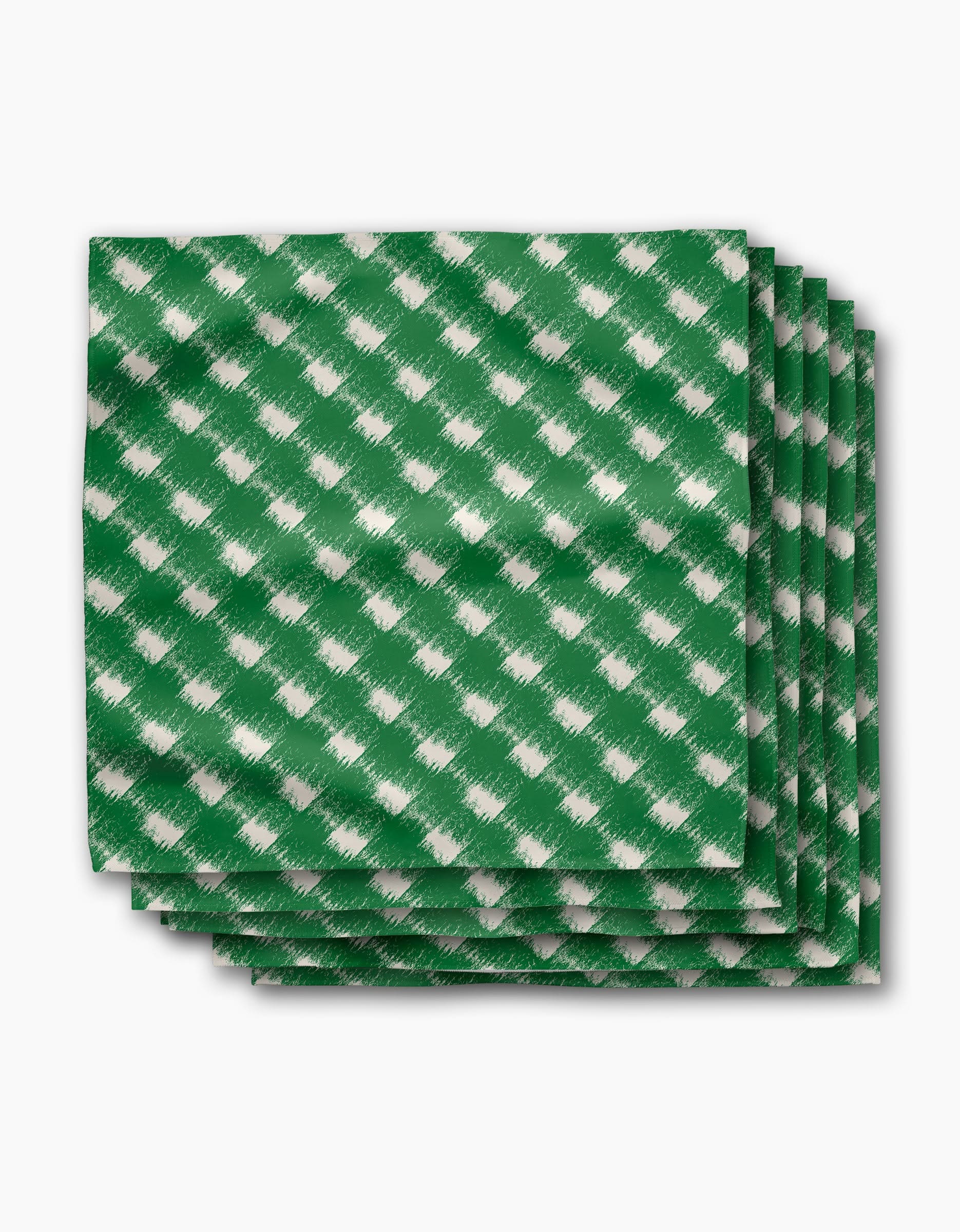 The Geometry Hairy Check Green Dinner Napkin Set features four green napkins with a white diagonal checkered pattern, made from recycled materials and neatly stacked on a white background.