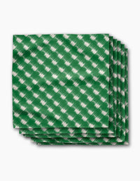 The Geometry Hairy Check Green Dinner Napkin Set features four green napkins with a white diagonal checkered pattern, made from recycled materials and neatly stacked on a white background.