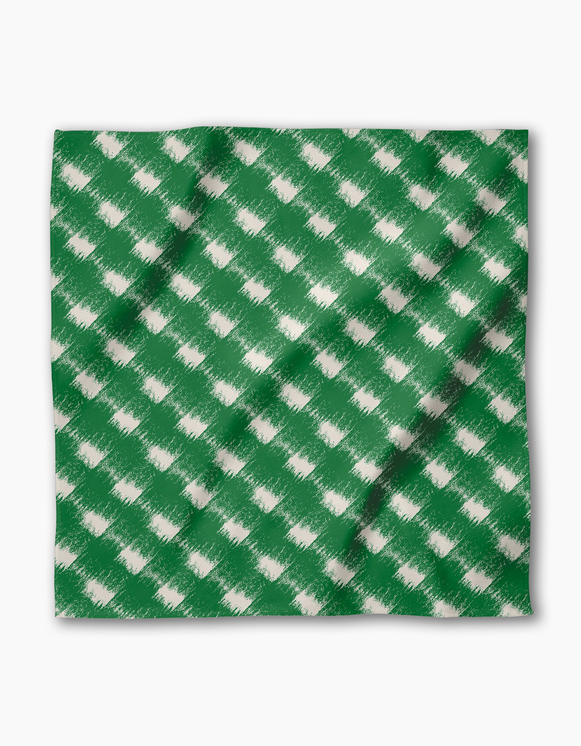 The Geometry Hairy Check Green is a reusable napkin made from recycled materials, featuring a green, square cloth with a white brushed, diagonal check pattern. It has slight folds and shadows, set against a plain white background.